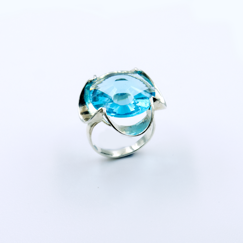 A silver ring combined with a crystal in a shade of aquamarine