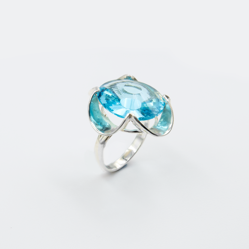 A silver ring combined with a crystal in a shade of aquamarine