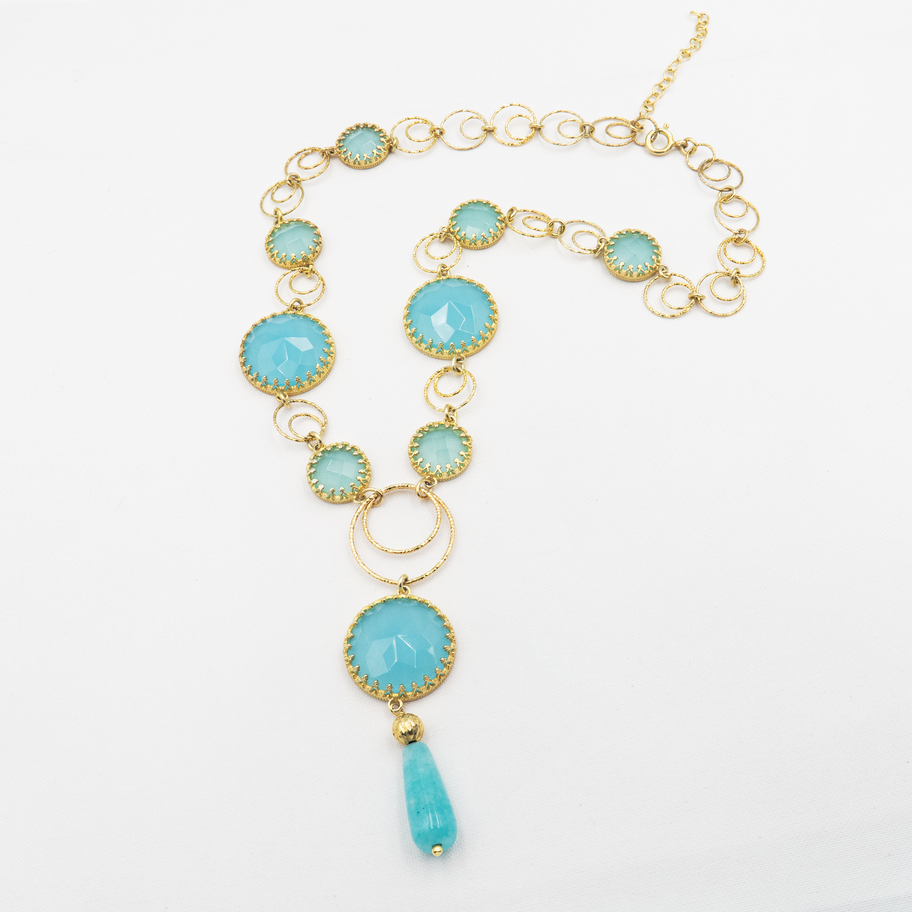 ענק כסף מרהיב בעבודת יד, עם אבנים בגוונים המזכירים את הים התיכון – טורקיז, תכלת, ירקרק עמוק ושברי אור כשל גלים בשמש. התכשיט מעורר תחושת חופש, שלווה ורעננות, כמו נשימה עמוקה מול הים. העיצוב משלב בין קווים טבעיים לגימור אלגנטי, והתוצאה – תכשיט עם נוכחות רגועה אך ברורה. אבני החן נבחרו בקפידה ליצירת מעבר הרמוני של צבעים המדמים תנועת מים, והכסף מוסיף ברק עדין שמדגיש את היופי שבפשטות. מתאים במיוחד לאוהבות הסגנון הבוהמי-אלגנטי, ולמי שמחפשת תכשיט שיבטא את אהבתה לטבע ולים. משתלב באופן נפלא עם לבוש קיצי, לבן, ג'ינס א