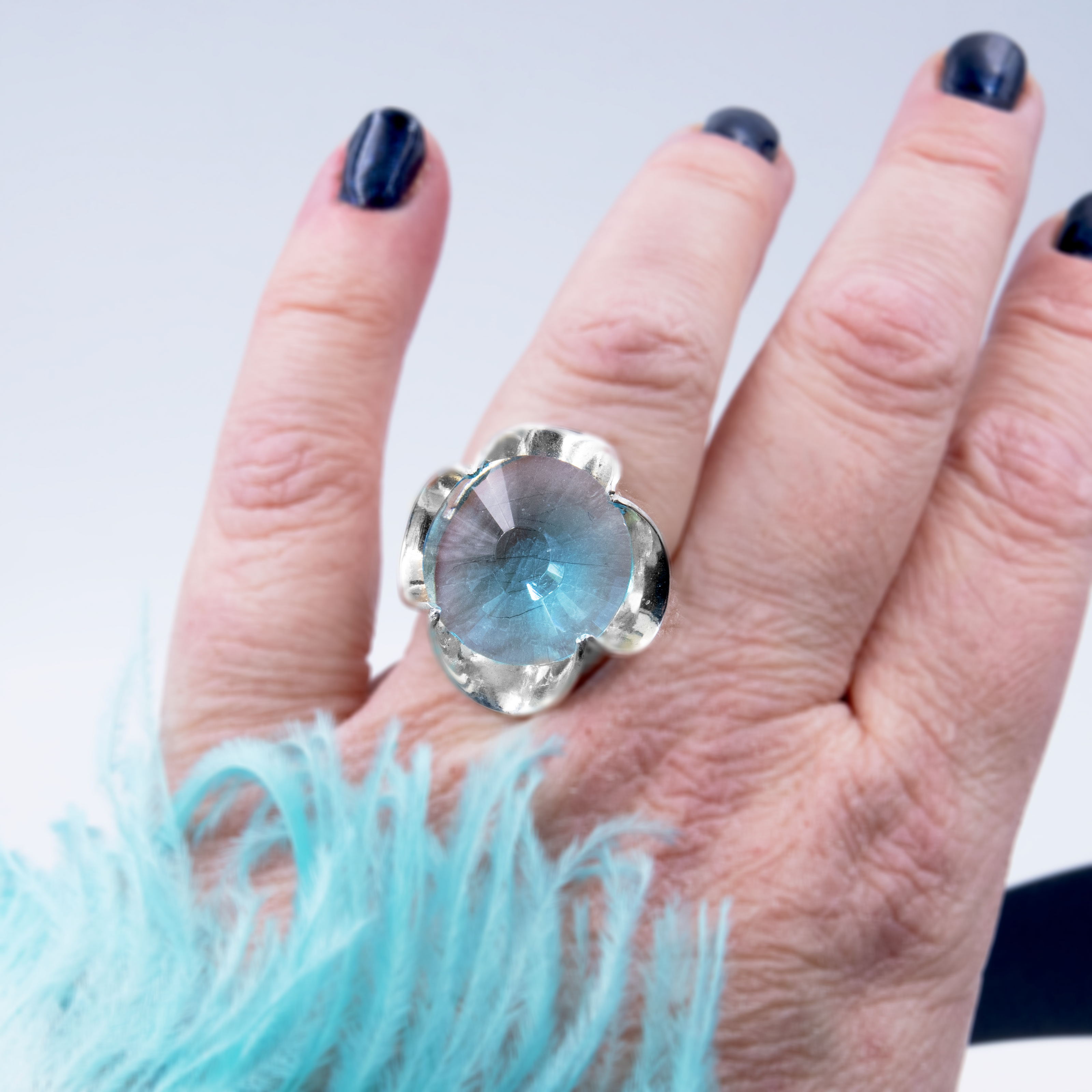 A silver ring combined with a crystal in a shade of aquamarine