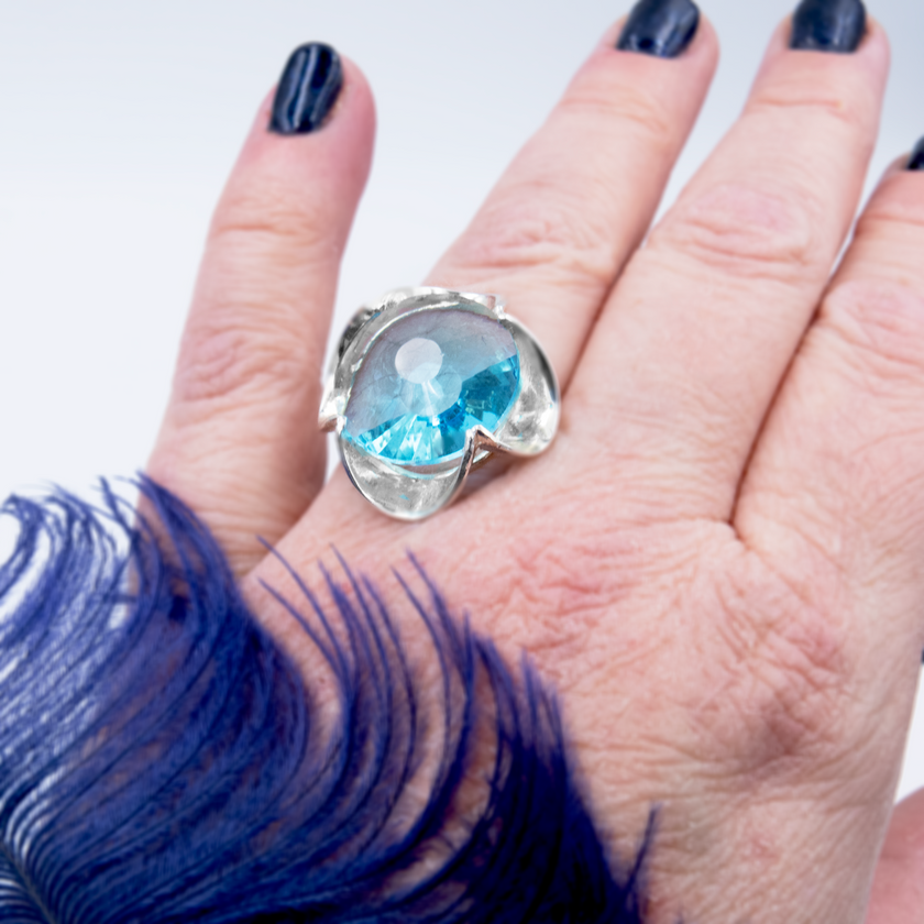 A silver ring combined with a crystal in a shade of aquamarine