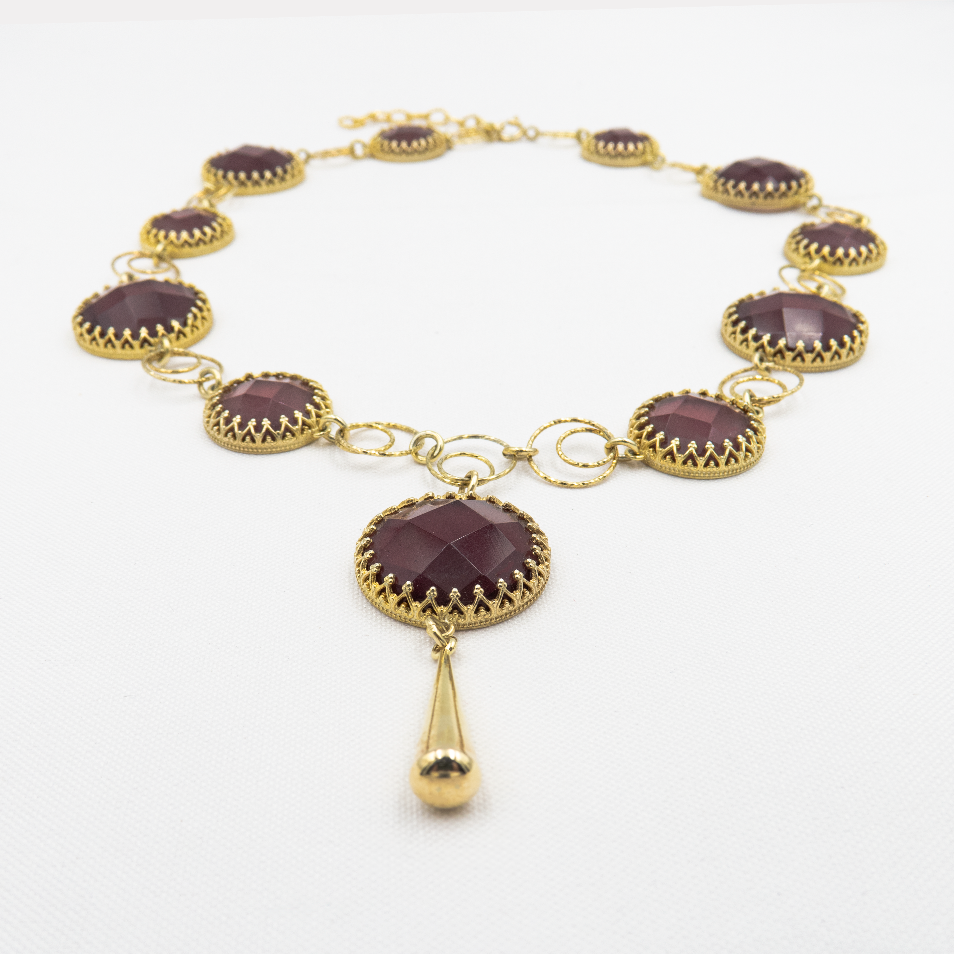 שרשרת בהשראת רומנטיקה עתיקה – אבן בורדו כהה עם ניצוץ פנימי, עוטפת את הצוואר במראה נשי ונוגע ללב. עבודת יד קפדנית, עם תשומת לב לכל פרט – מהאבן ועד סוגר השרשרת.