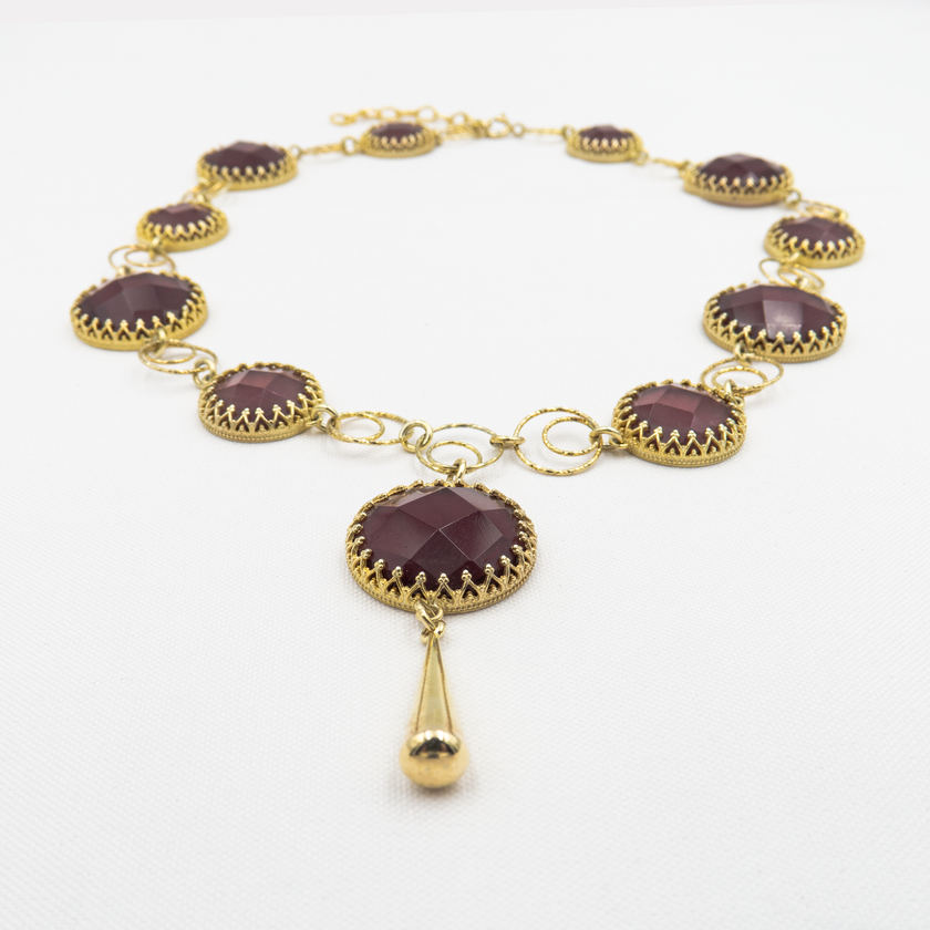 שרשרת בהשראת רומנטיקה עתיקה – אבן בורדו כהה עם ניצוץ פנימי, עוטפת את הצוואר במראה נשי ונוגע ללב. עבודת יד קפדנית, עם תשומת לב לכל פרט – מהאבן ועד סוגר השרשרת.