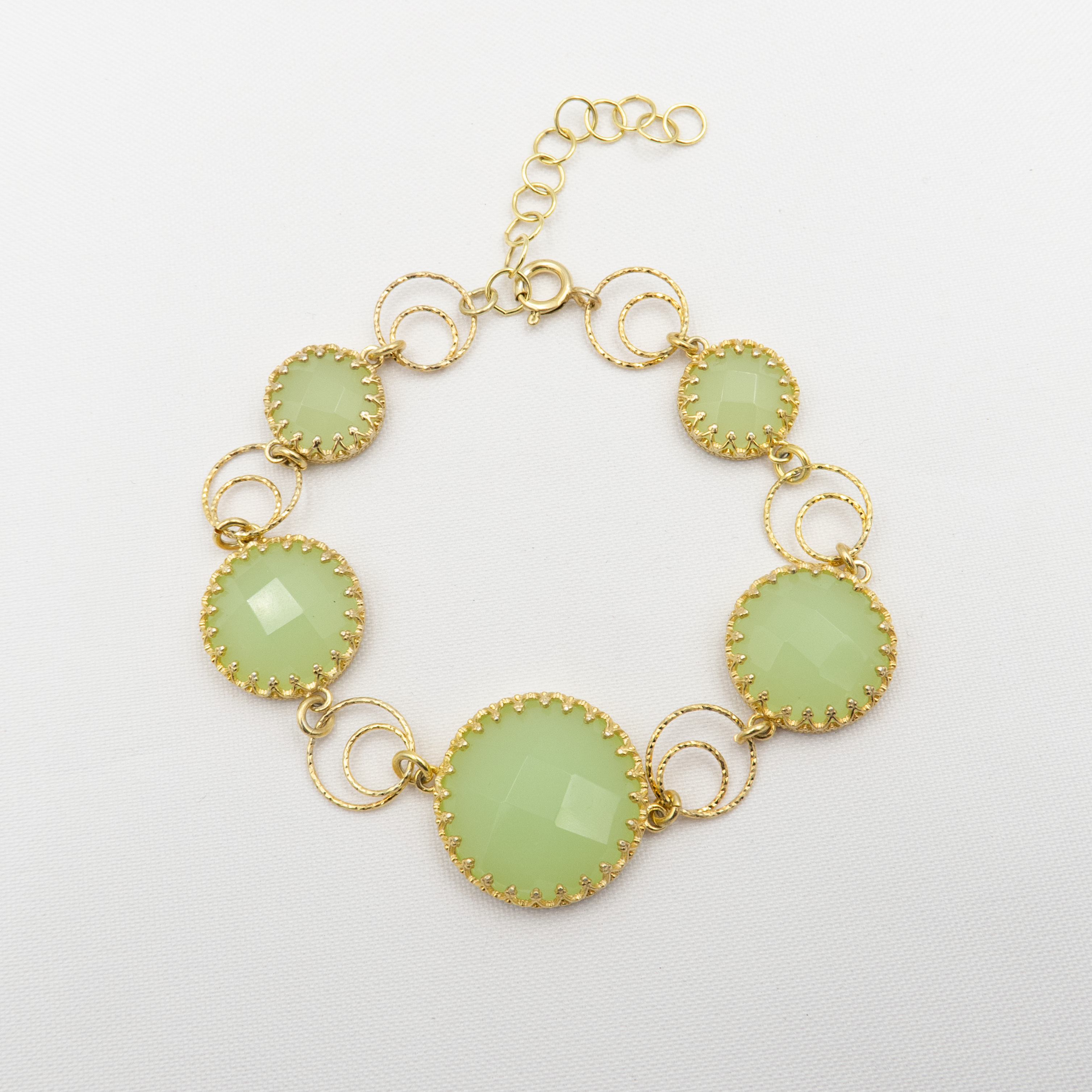 צמיד כסף בעבודת יד, משובץ בשורת אבני אופליט ירוקות בגוונים פסטליים רכים – ממנטה בהיר ועד ירוק עמוק עם ברק חלבי עדין. כל אבן מעובדת בגימור פאות או מלוטשת למראה פנינה מודרנית, ומשובצת במסגרת כסף מעודנת שמדגישה את צבעה. האבנים משתלבות זו בזו ויוצרות רצף הרמוני, כמו גלי ים שקטים. עיצוב עשיר ונשי, עם נוכחות רגועה אך בולטת. מתאים לנשים שמחפשות תכשיט מלא אור, רוגע וסטייל טבעי, ומושלם כמתנה עם משמעות.

