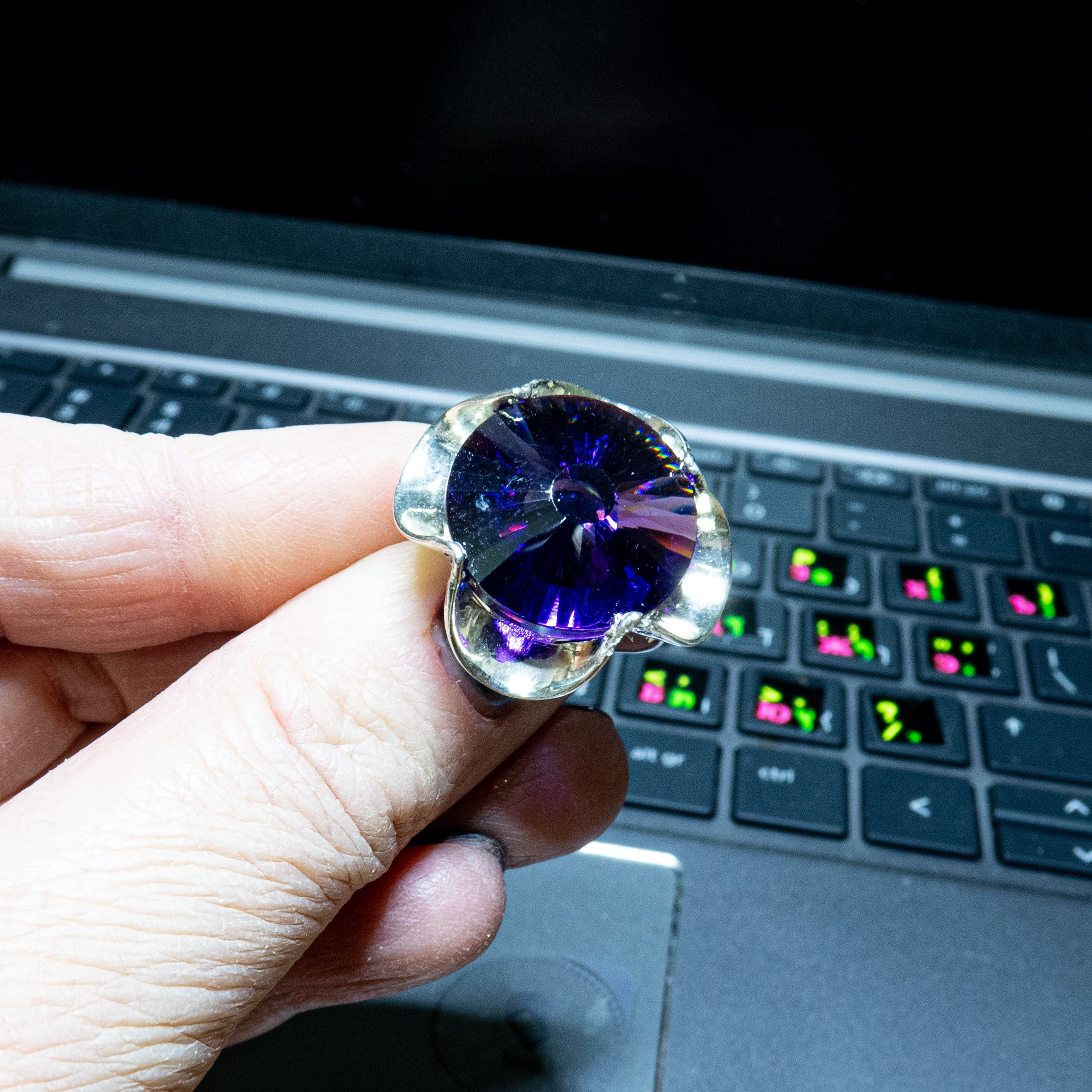 טבעת כסף בעבודת יד, משולבת בקריסטל סגול בגוון המזכיר את אבן האמטיסט – גוון מהפנט שנע בין לבנדר עדין לסגול כהה. האבן חתוכה בפאות מדויקות ויוצרת משחקי אור שמעניקים לה הבהוב מהפנט. השילוב בין גוון האבן האצילי לבין מתכת הכסף המלוטשת מעניק לטבעת חיבור בין חוזק לעדינות, בין קלאסיקה לאנרגיה מודרנית. התכשיט מתאים לנשים שמחפשות עומק, הבעה אישית ומיוחדת שאינה מובנת מאליה. קריסטל בגוון אמטיסט מסמל חכמה אינטואיטיבית – ומתאים כתוספת למראה יומיומי מלא חן או כתכשיט עם משמעות לערב מיוחד.