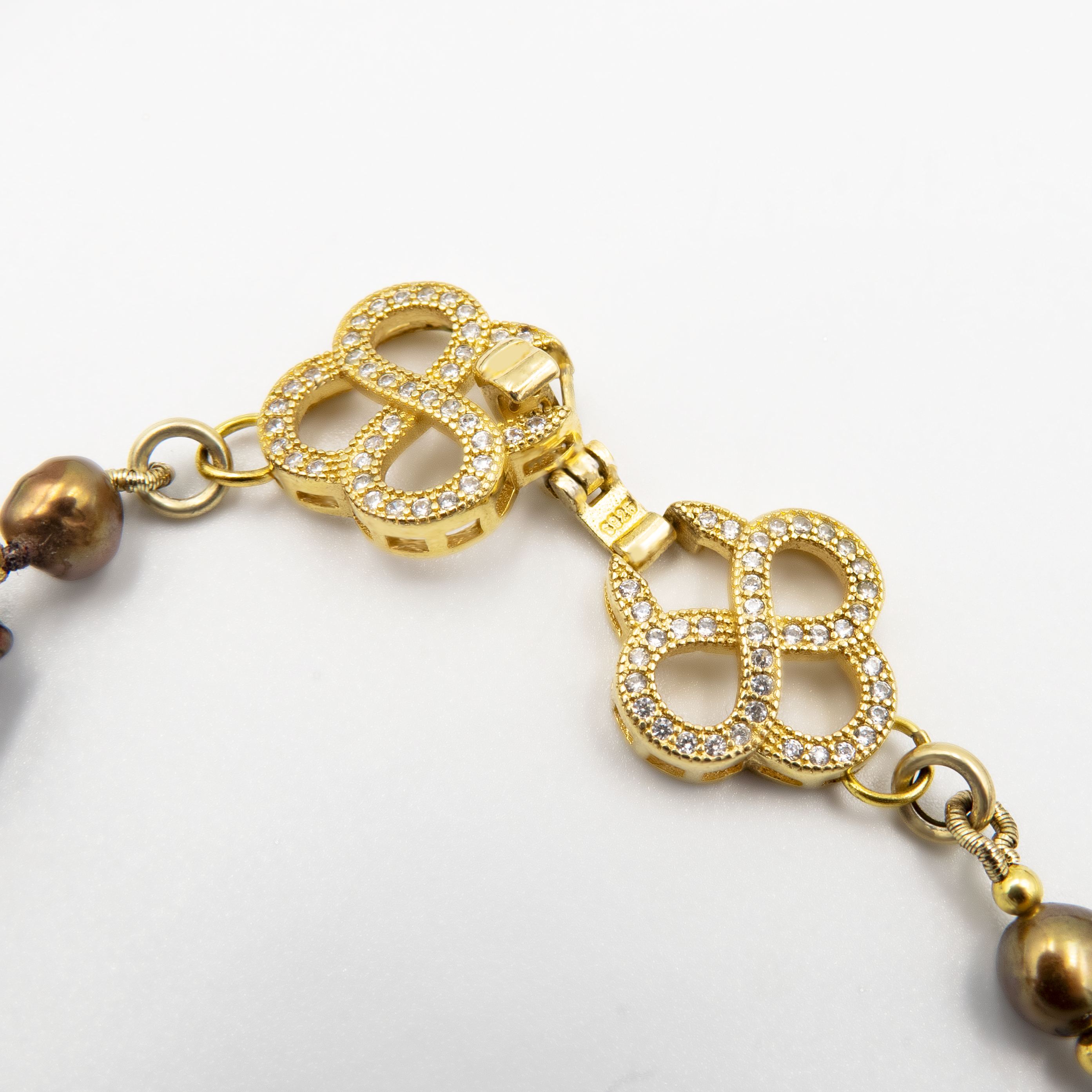 פריט בעיצוב לא שגרתי, מלא נוכחות המורכבת מפניני בארוק טבעיות בגוון שוקולד עמוק, עם אביזרים בציפוי זהב שמדגישים את צורתן הבלתי אחידה והמרקם החי של כל פנינה. הברק המטאלי החם של הפנינים משתלב באופן הרמוני עם הנגיעות המוזהבות, ויוצר תחושה של חומר חי ונושם. שילוב בין חוזק טבעי ליוקרה נינוחה – אידיאלי לאירוע ערב, להופעה עם אמירה או כמתנה מרשימה לאישה מיוחדת. פניני הבארוק, כל אחת עם אישיות משלה, הופכות את השרשרת הזו לשרשרת שלא דומה לשום דבר אחר – טבעית, אותנטית ומרשימה.