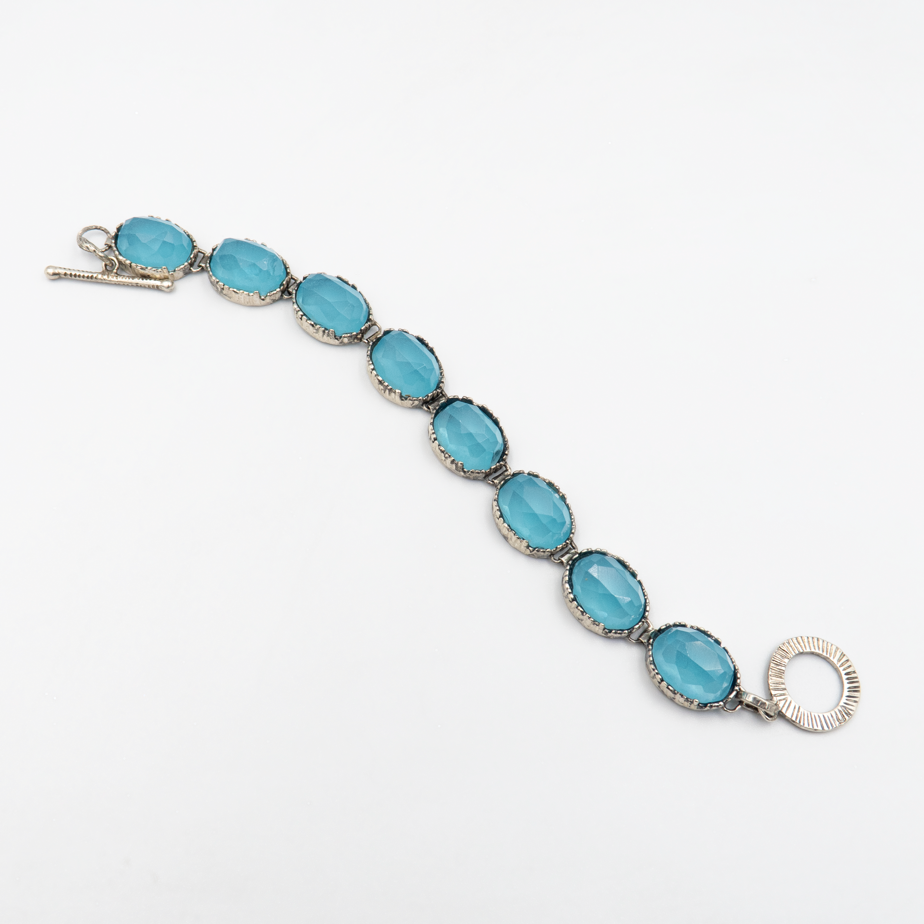 צמיד כסף סטרלינג בעבודת יד, משובץ באבן אופליט כחולה בגוון פנינה עמוק עם נצנוץ חלבי. האבן משנה גווניה לפי התאורה – מכחול שמיים רך ועד כחול עמוק ומסתורי. הצמיד מתאים לנשים שאוהבות עיצוב מינימליסטי עם טאץ' של ייחוד. מושלם ליום-יום או לאירועים מיוחדים.

