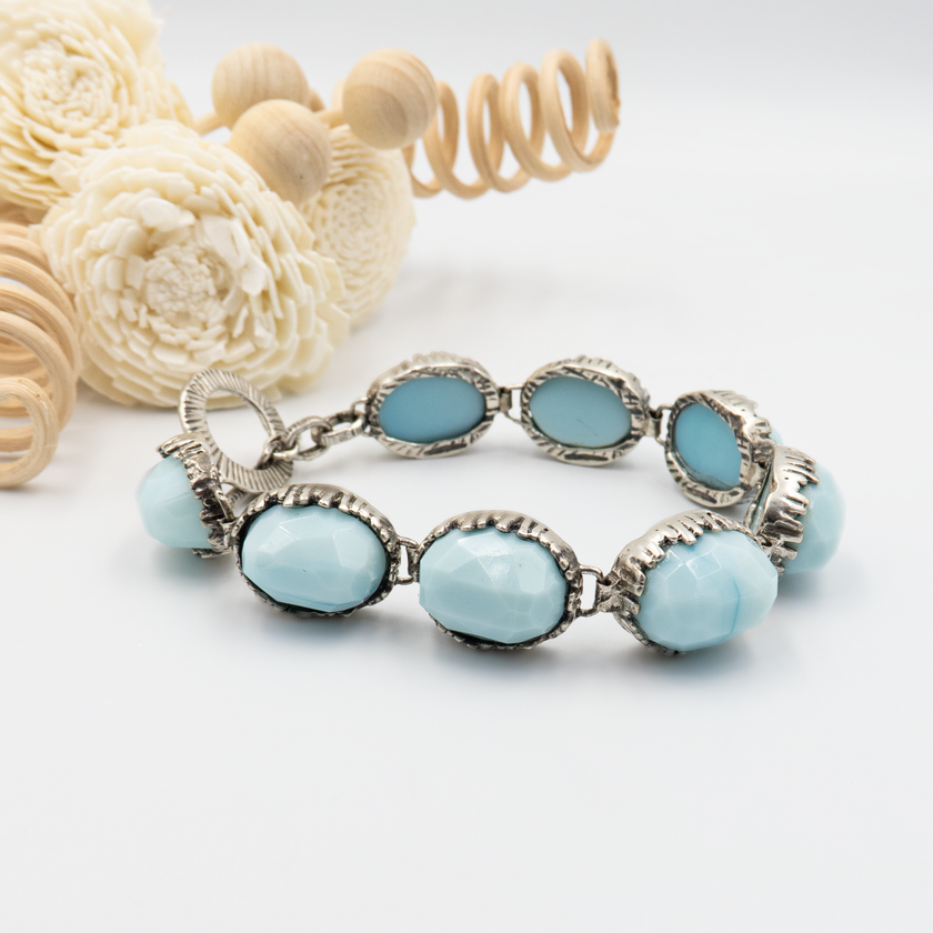 תכשיט כסף בעבודת יד עם אבן אופליט בגוונים כחולים-לבנים המשתנים לפי התאורה. האבן מזכירה שמיים בהירים עם אפקט פניני זוהר, והצמיד מתאים ליום-יום או לאירועים מיוחדים. עיצוב מוקפד ונוח, אידיאלי כמתנה מרגשת או כתכשיט אישי עם נוכחות אלגנטית.

