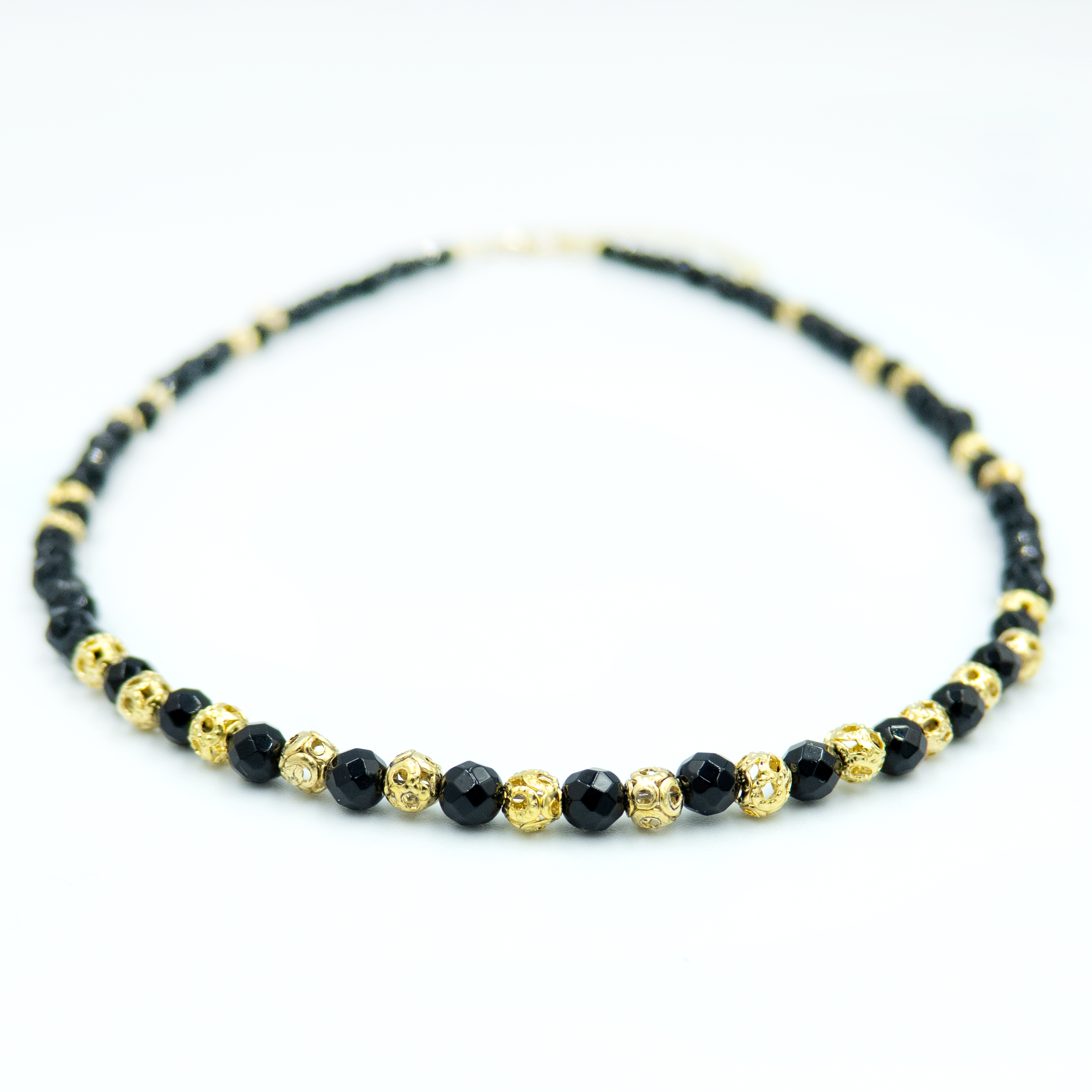 תכשיט שמשדר עוצמה עדינה – שרשרת עם אבני אוניקס בגוון שחור מלוטש, בעלות ברק טבעי ומרקם אחיד, יחד עם אלמנטים מצופי זהב בעיצוב מודרני. השרשרת מתאימה לנשים שמחפשות שילוב בין קלאסי לאורבני, בין חומר טבעי לגימור יוקרתי. האבנים בנויות בצורה סימטרית שנותנת תחושת איזון ודיוק, והזהב מוסיף תחושת חמימות ונשיות. אידיאלי לכל מי שמחפשת אקססורי עם נוכחות אבל לא צורח – אלא פשוט מדבר אל מי שצריך להקשיב.

