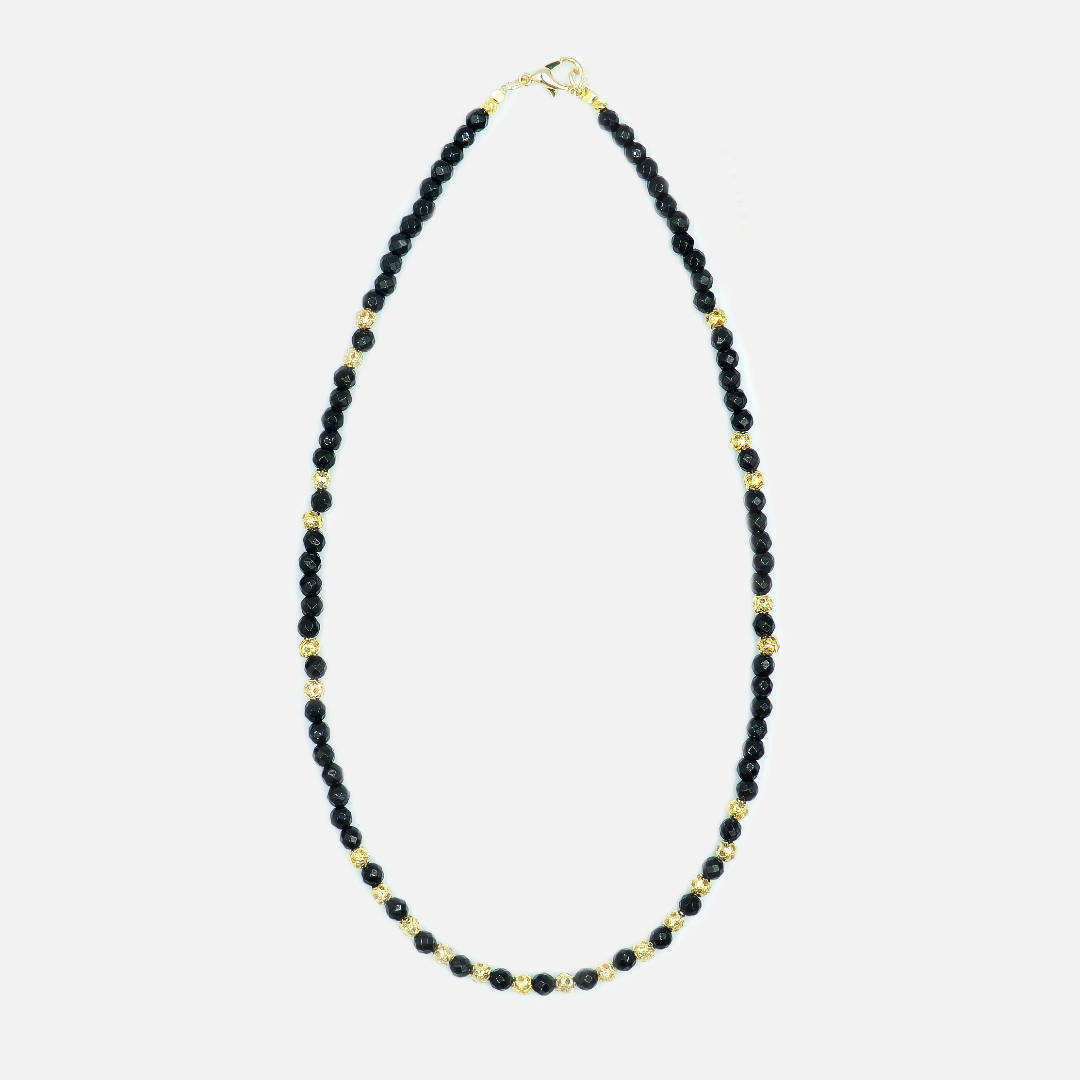 תכשיט שמשדר עוצמה עדינה – שרשרת עם אבני אוניקס בגוון שחור מלוטש, בעלות ברק טבעי ומרקם אחיד, יחד עם אלמנטים מצופי זהב בעיצוב מודרני. השרשרת מתאימה לנשים שמחפשות שילוב בין קלאסי לאורבני, בין חומר טבעי לגימור יוקרתי. האבנים בנויות בצורה סימטרית שנותנת תחושת איזון ודיוק, והזהב מוסיף תחושת חמימות ונשיות. אידיאלי לכל מי שמחפשת אקססורי עם נוכחות אבל לא צורח – אלא פשוט מדבר אל מי שצריך להקשיב.

