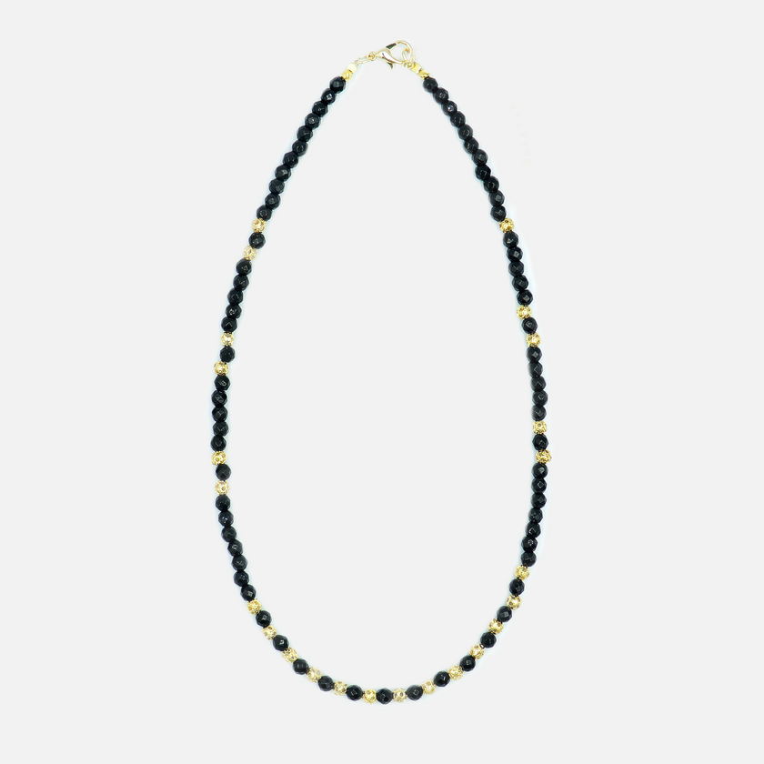 תכשיט שמשדר עוצמה עדינה – שרשרת עם אבני אוניקס בגוון שחור מלוטש, בעלות ברק טבעי ומרקם אחיד, יחד עם אלמנטים מצופי זהב בעיצוב מודרני. השרשרת מתאימה לנשים שמחפשות שילוב בין קלאסי לאורבני, בין חומר טבעי לגימור יוקרתי. האבנים בנויות בצורה סימטרית שנותנת תחושת איזון ודיוק, והזהב מוסיף תחושת חמימות ונשיות. אידיאלי לכל מי שמחפשת אקססורי עם נוכחות אבל לא צורח – אלא פשוט מדבר אל מי שצריך להקשיב.

