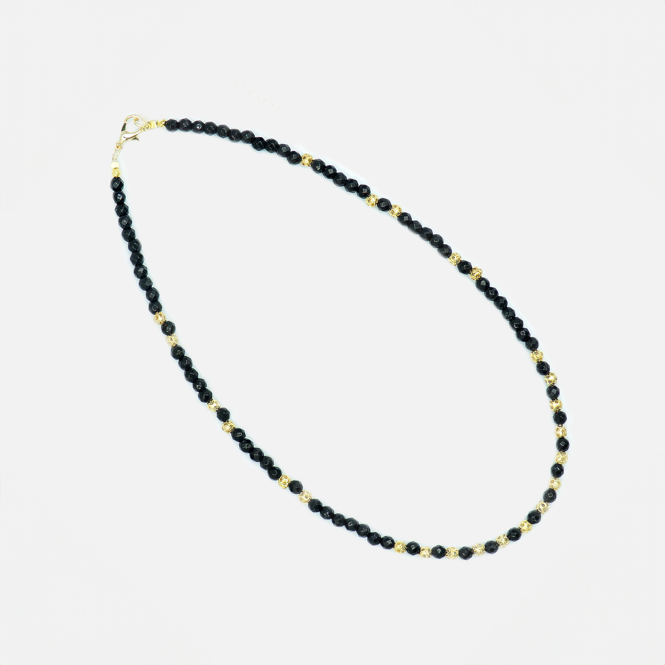 שרשרת אלגנטית בעבודת יד, עשויה מאבני אוניקס שחור מבריקות בגימור מלוטש, המשולבות עם קישוטים עדינים בציפוי זהב. הניגוד בין הגוון השחור העמוק לזהב החם יוצר מראה יוקרתי אך נגיש, עם תחושת עוצמה שקטה ונוכחות נשית מדויקת. השרשרת מתאימה לשימוש יומיומי וגם כהשלמה להופעה רשמית או לערב, ומומלצת לנשים שאוהבות תכשיטים עם אמירה, אך גם עם רוך ואלגנטיות. החיבור בין החומר הגולמי לבין הקווים הנקיים הופך את התכשיט הזה לקלאסי עם טוויסט מודרני.

