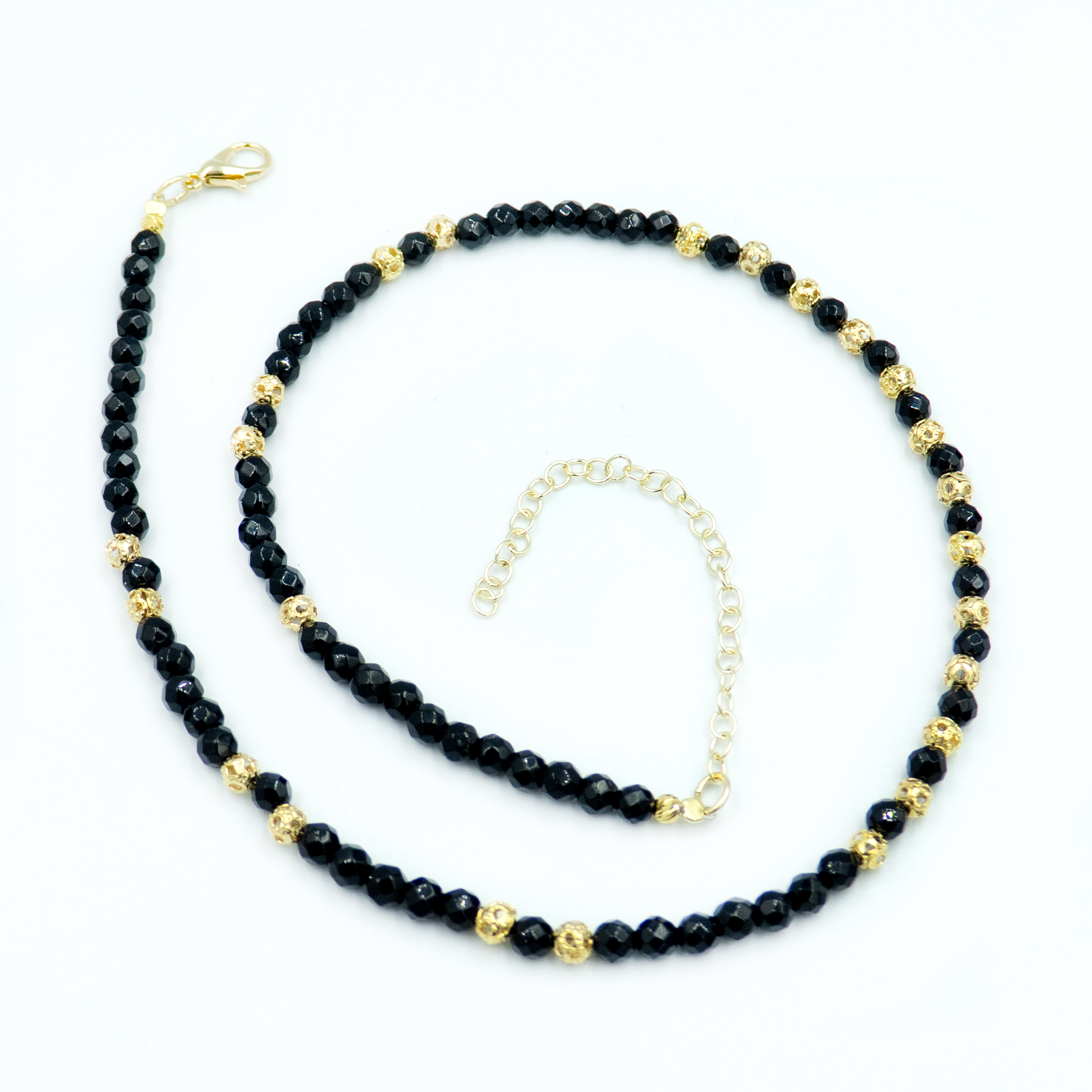 שרשרת אוניקס מרשימה בעבודת יד, עם אבנים כהות ומסתוריות המשתלבות בהרמוניה עם קישוטים עדינים בציפוי זהב מבריק. השרשרת יוצרת איזון בין חושך לאור, בין עומק לברק, בין קווים חדים לרכות עיצובית. מתאימה לשילוב עם צבעים ניטרליים או כל הופעה שדורשת טאץ' נוסף של תחכום. תכשיט שמזמין אותך להביע את עצמך בעדינות, בבחירה מושכלת של חומרים, גימור ואיכות – מתנה נהדרת גם לעצמך.

