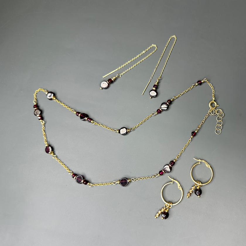 שרשרת זהב 14 קראט משובצת אבן גארנט, לצד עגילי חישוק ועדינים בסגנון שרשרת – העגילים מופיעים להמחשה בלבד.

אם התמונה מתמקדת בעיקר בפרטי השרשרת, אפשר לנסח גם כך:

תקריב של שרשרת זהב 14K עם אבן גארנט אדומה, לצד עגילי חישוק ועדינים המוצגים להמחשה בלבד.