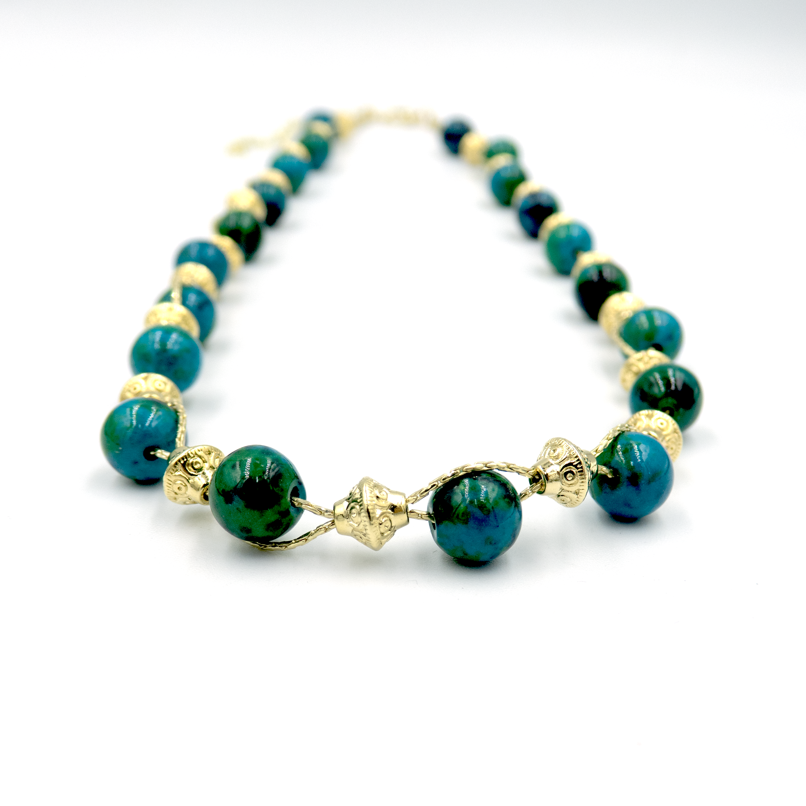 שרשרת עבודת יד מאבני כריסוקולה טבעיות בגווני טורקיז, ירוק וכחול עמוק – טקסטורה צבעונית שמחברת בין שקט לעוצמה. כל אבן נבחרת בקפידה ומציגה דפוס ייחודי משלה, אין שתיים זהות – כל תכשיט מספר סיפור אחר. הכריסוקולה ידועה כאבן המוכרת בכוחות ההרגעה והחיזוק שלה, כזו שמחברת את הלובשת לאנרגיה פנימית של שקט וביטחון. העיצוב של השרשרת שומר על קו נקי ומוקפד, ומבליט את יופיין הגולמי של האבנים. מתאים למי שמחפשת סטייל אישי עם נשמה.