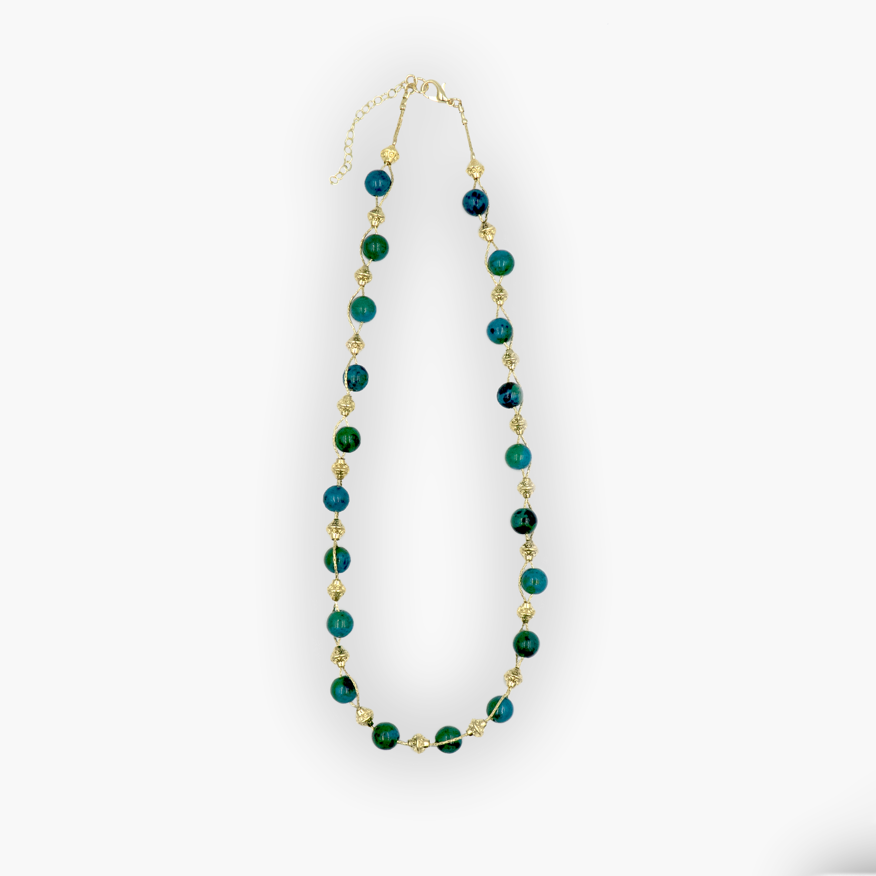 שרשרת עבודת יד מאבני כריסוקולה טבעיות בגווני טורקיז, ירוק וכחול עמוק – הרכב צבעים שמקרין שלווה פנימית. כל אבן נבחרת בקפידה ומציגה דפוס ייחודי משלה, הופך כל שרשרת לייחודית ובלתי חוזרת. הכריסוקולה ידועה כאבן המוכרת בכוחות ההרגעה והחיזוק שלה, כזו שמחברת את הלובשת לאנרגיה פנימית של שקט וביטחון. העיצוב של השרשרת שומר על קו נקי ומוקפד, ומבליט את יופיין הגולמי של האבנים. מתאים למי שמחפשת תכשיט שמדבר שקט – אך מלא נוכחות.
