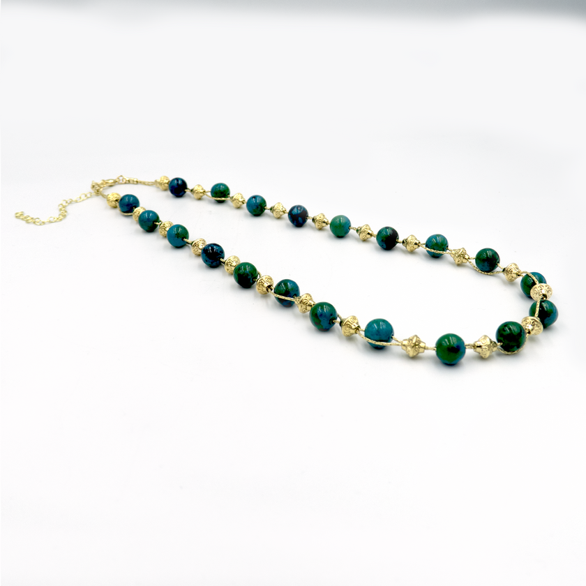 שרשרת עבודת יד מאבני כריסוקולה טבעיות בגווני טורקיז, ירוק וכחול עמוק – מפגש הרמוני בין גווני טבע עזים. כל אבן נבחרת בקפידה ומציגה דפוס ייחודי משלה, אין שתיים זהות – כל תכשיט מספר סיפור אחר. הכריסוקולה ידועה כאבן המוכרת בכוחות ההרגעה והחיזוק שלה, כזו שמחברת את הלובשת לאנרגיה פנימית של שקט וביטחון. העיצוב של השרשרת שומר על קו נקי ומוקפד, ומבליט את יופיין הגולמי של האבנים. מתאים למי שמחפשת תכשיט שמדבר שקט – אך מלא נוכחות.