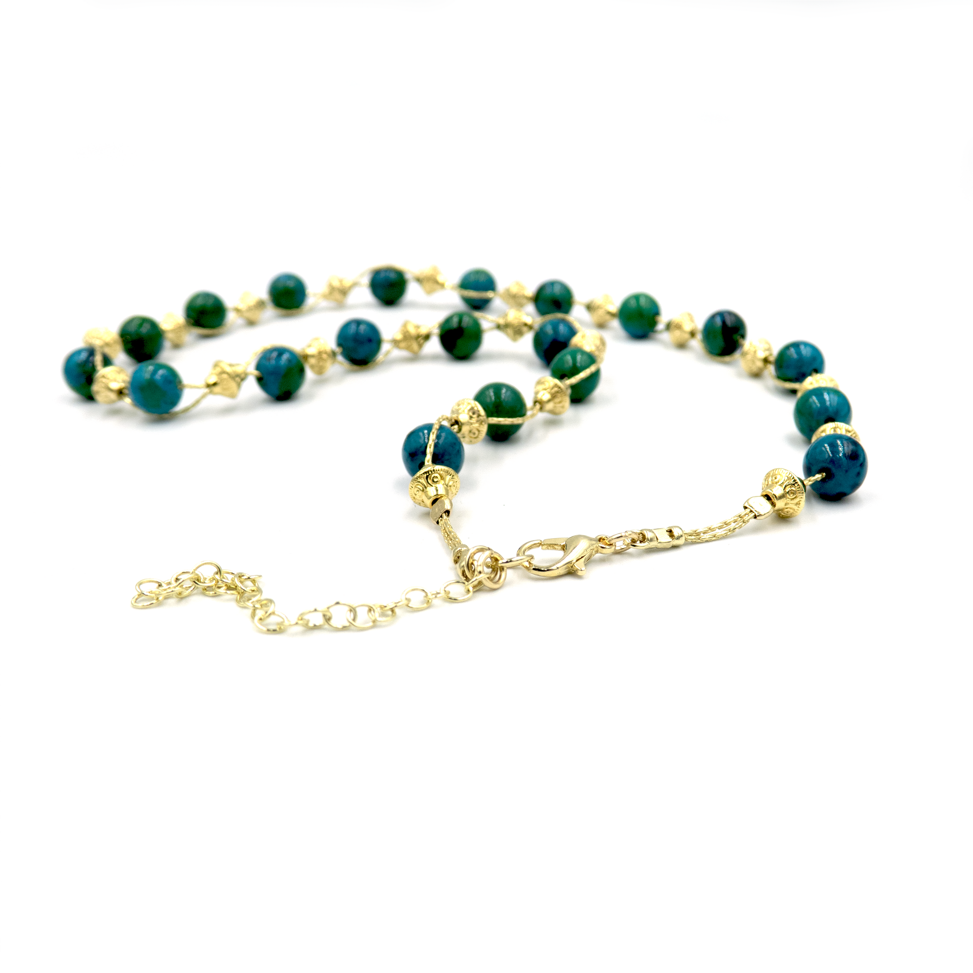 שרשרת עבודת יד מאבני כריסוקולה טבעיות בגווני טורקיז, ירוק וכחול עמוק – מפגש הרמוני בין גווני טבע עזים. כל אבן נבחרת בקפידה ומציגה דפוס ייחודי משלה, הופך כל שרשרת לייחודית ובלתי חוזרת. הכריסוקולה ידועה כאבן של רכות וחיבור פנימי, כזו שמחברת את הלובשת לאנרגיה פנימית של שקט וביטחון. העיצוב של השרשרת שומר על קו נקי ומוקפד, ומבליט את יופיין הגולמי של האבנים. מתאים למי שמחפשת תכשיט שמדבר שקט – אך מלא נוכחות.