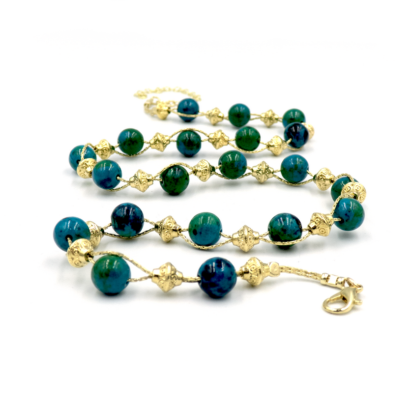 שרשרת עבודת יד מאבני כריסוקולה טבעיות בגווני טורקיז, ירוק וכחול עמוק – מפגש הרמוני בין גווני טבע עזים. כל אבן נבחרת בקפידה ומציגה דפוס ייחודי משלה, הופך כל שרשרת לייחודית ובלתי חוזרת. הכריסוקולה ידועה כאבן המוכרת בכוחות ההרגעה והחיזוק שלה, כזו שמחברת את הלובשת לאנרגיה פנימית של שקט וביטחון. העיצוב של השרשרת שומר על קו נקי ומוקפד, ומבליט את יופיין הגולמי של האבנים. מתאים למי שמחפשת תכשיט שמדבר שקט – אך מלא נוכחות.