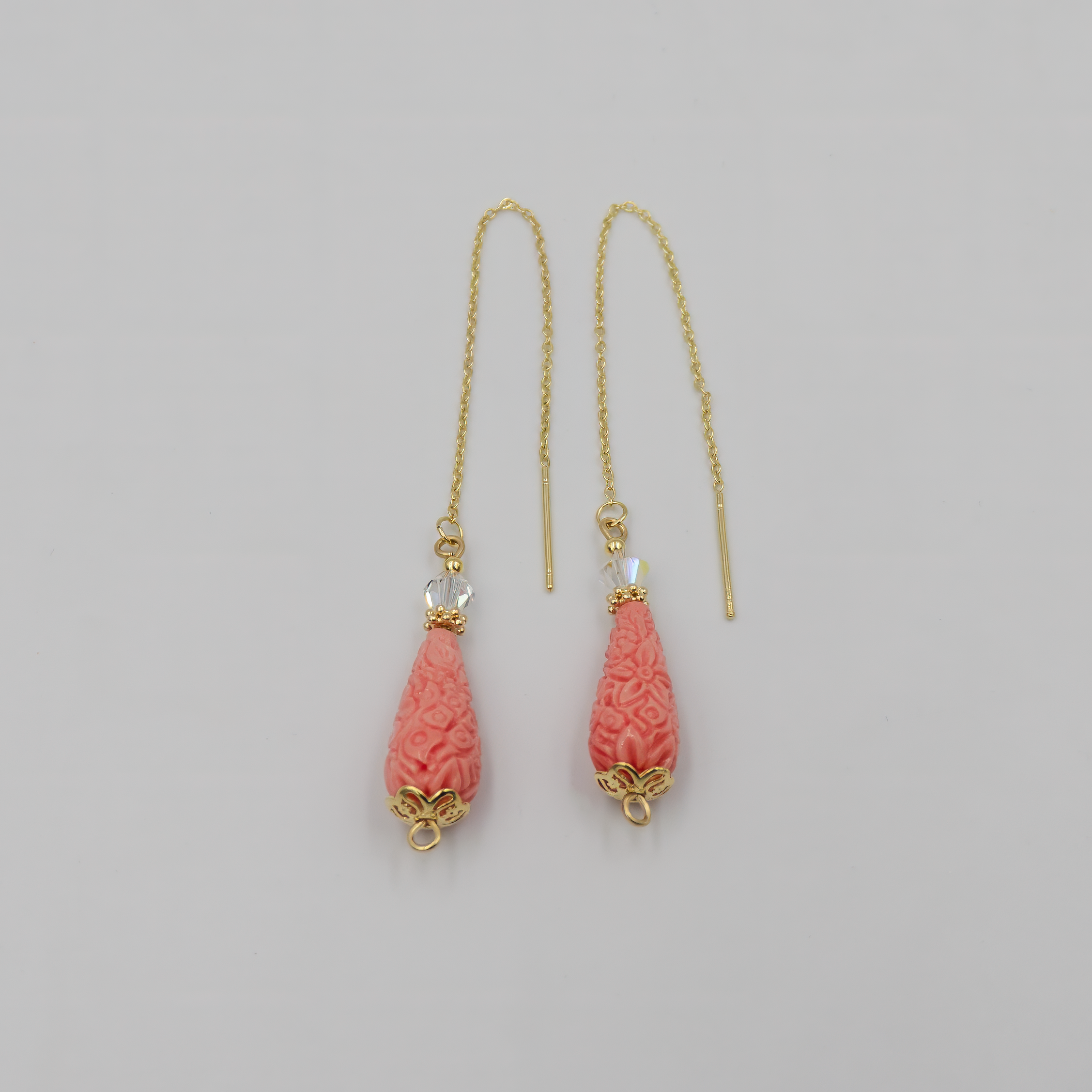 עגילי שרשרת בעבודת יד עם אבן קורל טבעית בגוון אדום עז, משתלשלת בעדינות מקצה שרשרת כסף או זהב. העיצוב משדר חמימות, נשיות ותחושת תנועה רכה. תכשיט עם נוכחות צבעונית שמוסיף חיים וסטייל לכל מראה – מושלם ליום וגם לערב.

