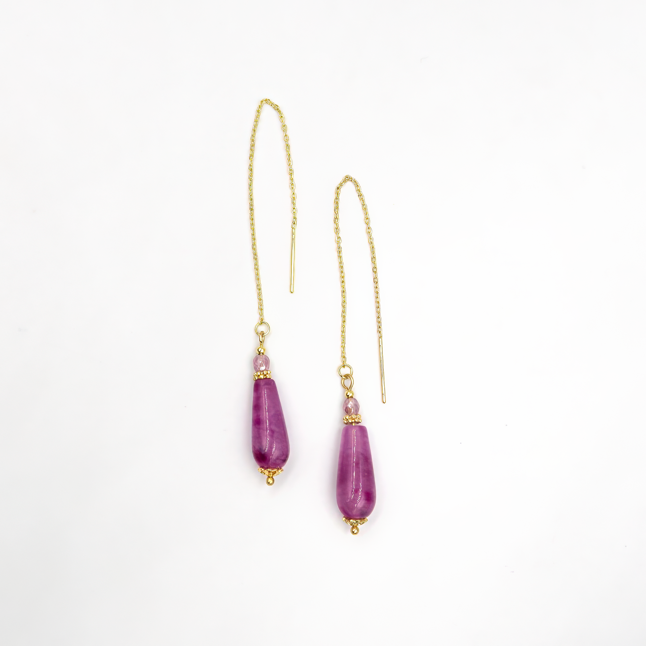 עגילי שרשרת בעבודת יד עם אבן אגת סגול בגוון עמוק ומרקם טבעי מרהיב. האבן משתלשלת מקצה שרשרת עדינה, ויוצרת מראה נשי, רך ואלגנטי. גווני הסגול משתנים בין אבן לאבן – כל זוג עגילים הוא יחיד ומיוחד. מתאים לנשים שאוהבות תכשיטים עם עומק, צבע ורוך.

