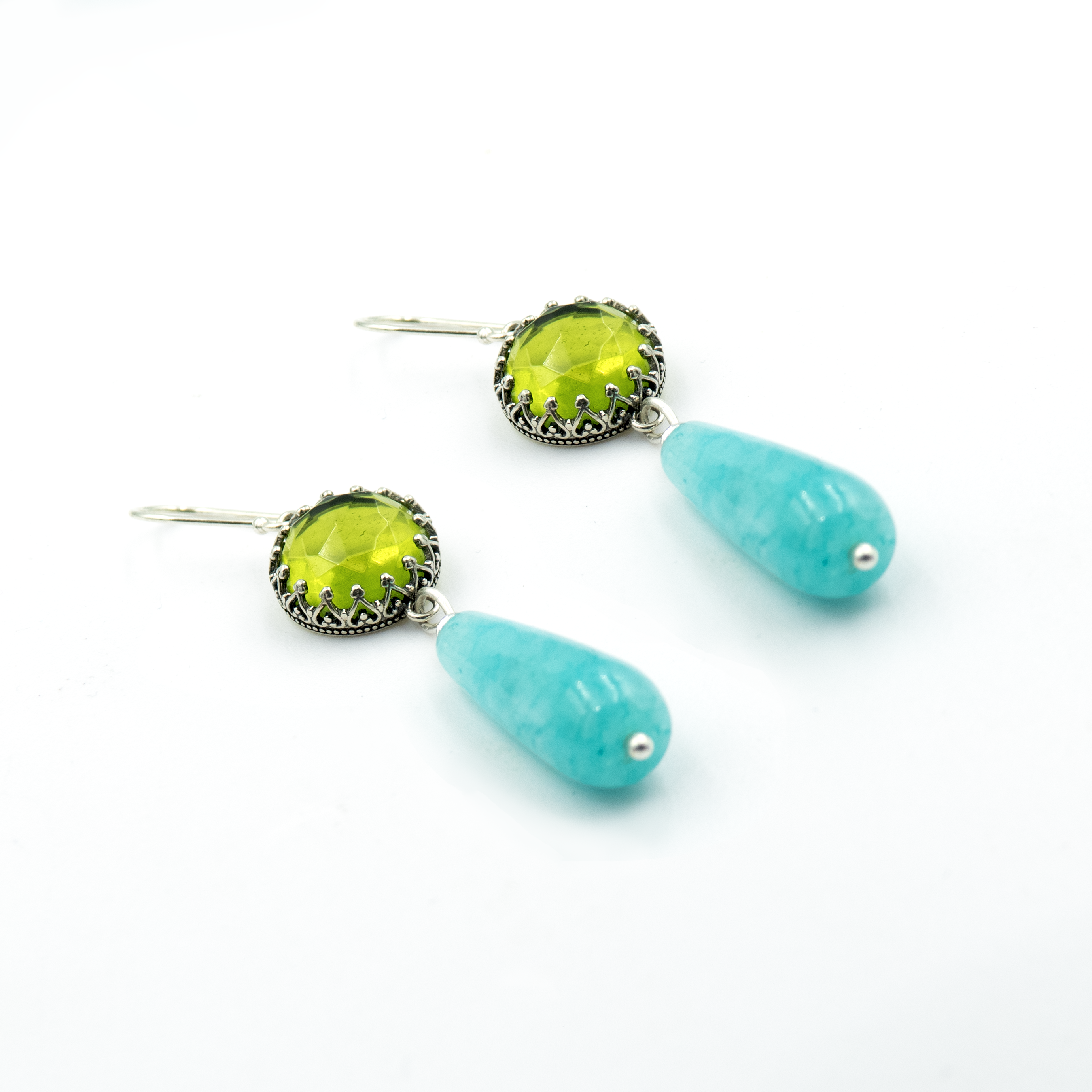 Elegant dangle earrings featuring a vibrant lime-green faceted gemstone framed in ornate silver and a smooth turquoise teardrop bead below. Handmade with precision, these colorful earrings blend antique charm and playful modern tones. Lightweight and eye-catching, they’re perfect for festive outfits, summer looks, or as a gift for someone who loves bold, artistic jewelry.

