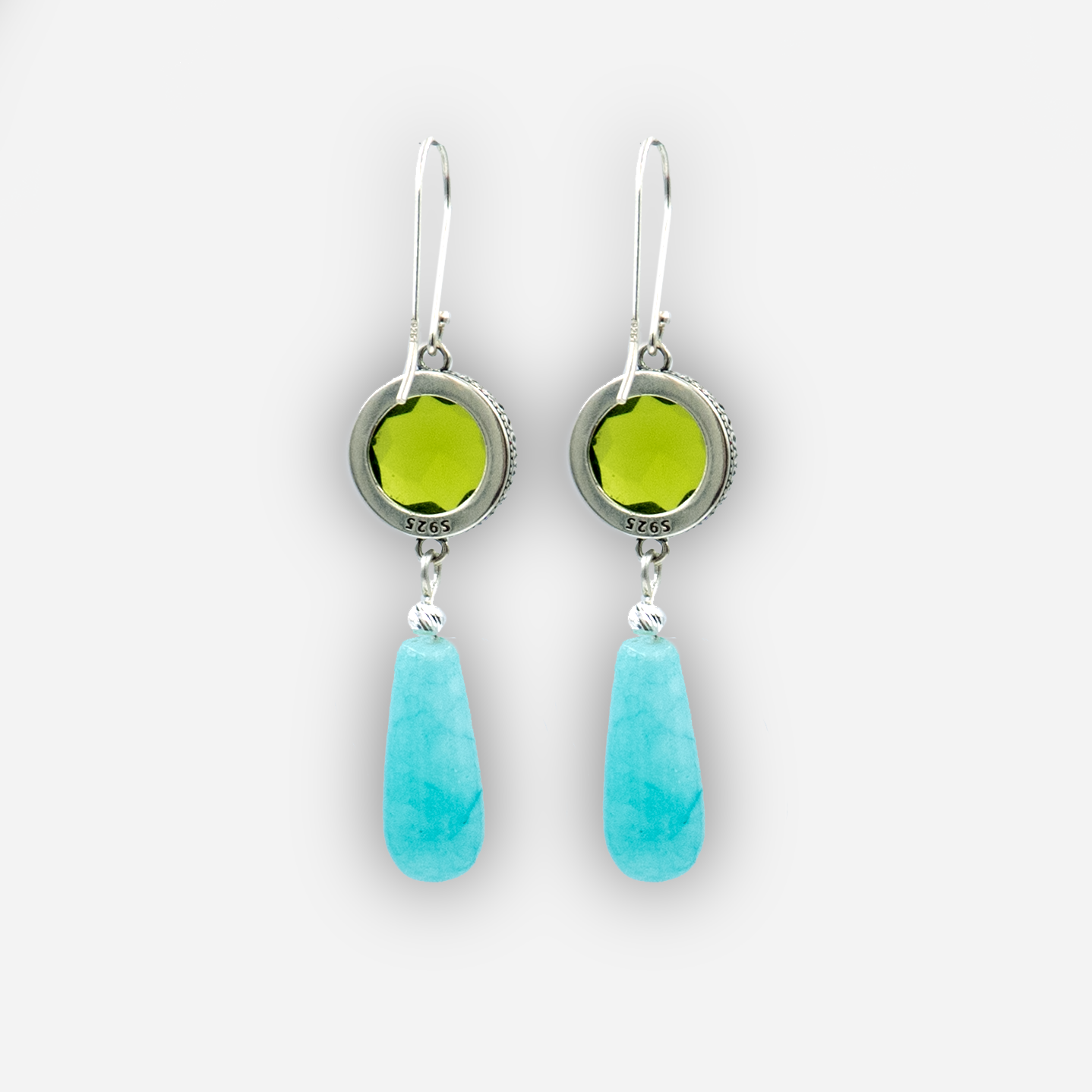 Playful and refined, these handcrafted earrings feature a brilliant green round stone set in an antique-style silver bezel, with a smooth turquoise teardrop suspended below. The contrast of textures and colors creates a lively accessory perfect for summer looks, boho chic styling, or casual evening wear. Unique and lightweight.

