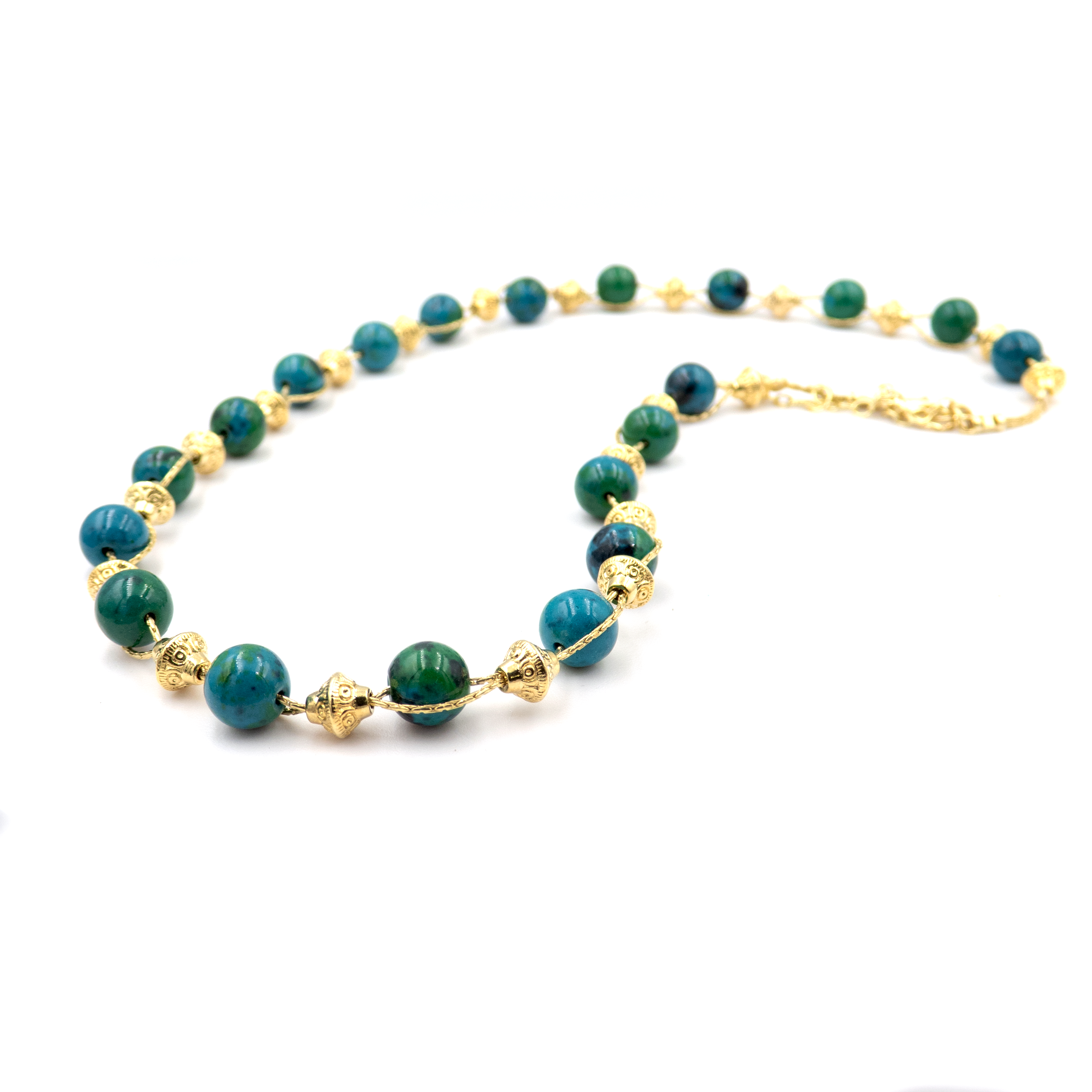 שרשרת עבודת יד מאבני כריסוקולה טבעיות בגווני טורקיז, ירוק וכחול עמוק – מפגש הרמוני בין גווני טבע עזים. כל אבן נבחרת בקפידה ומציגה דפוס ייחודי משלה, לכל שרשרת נוכחות משלה. הכריסוקולה ידועה כאבן עם אנרגיה טבעית של שלווה והרמוניה, כזו שמחברת את הלובשת לאנרגיה פנימית של שקט וביטחון. העיצוב של השרשרת שומר על קו נקי ומוקפד, ומבליט את יופיין הגולמי של האבנים. מתאים למי שמחפשת תכשיט שמדבר שקט – אך מלא נוכחות.