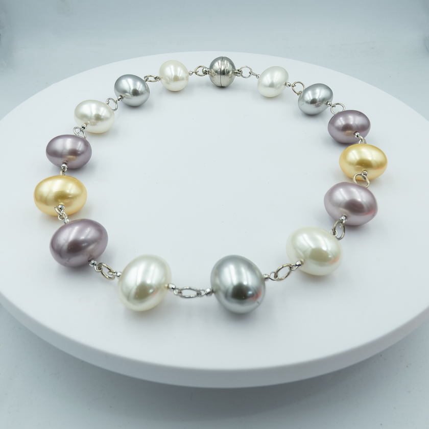 שרשרת פנינים מעוצבות בגוונים רכים ועליזים – שילוב מרענן של פנינים בגווני ורוד, סגול, כחול, ירוק וזהב, המסודרות בעבודת יד ליצירת תכשיט מלא שמחה ואופי. השרשרת יוצרת מראה נועז אך הרמוני, עם סגנון שמתאים לשגרת היום ולרגעים מיוחדים כאחד. פנינים באיכות גבוהה בעיצוב מוקפד משתלבות יחד בהרכב ייחודי שמושך את העין ומכניס צבע לכל הופעה. תכשיט שמתאים לאוהבות סטייל בולט, טאץ' שובב עם שיק קלאסי. שרשרת מושלמת לאביב ולקיץ, כמתנה משמחת או כתוספת מיוחדת למלתחה אישית.