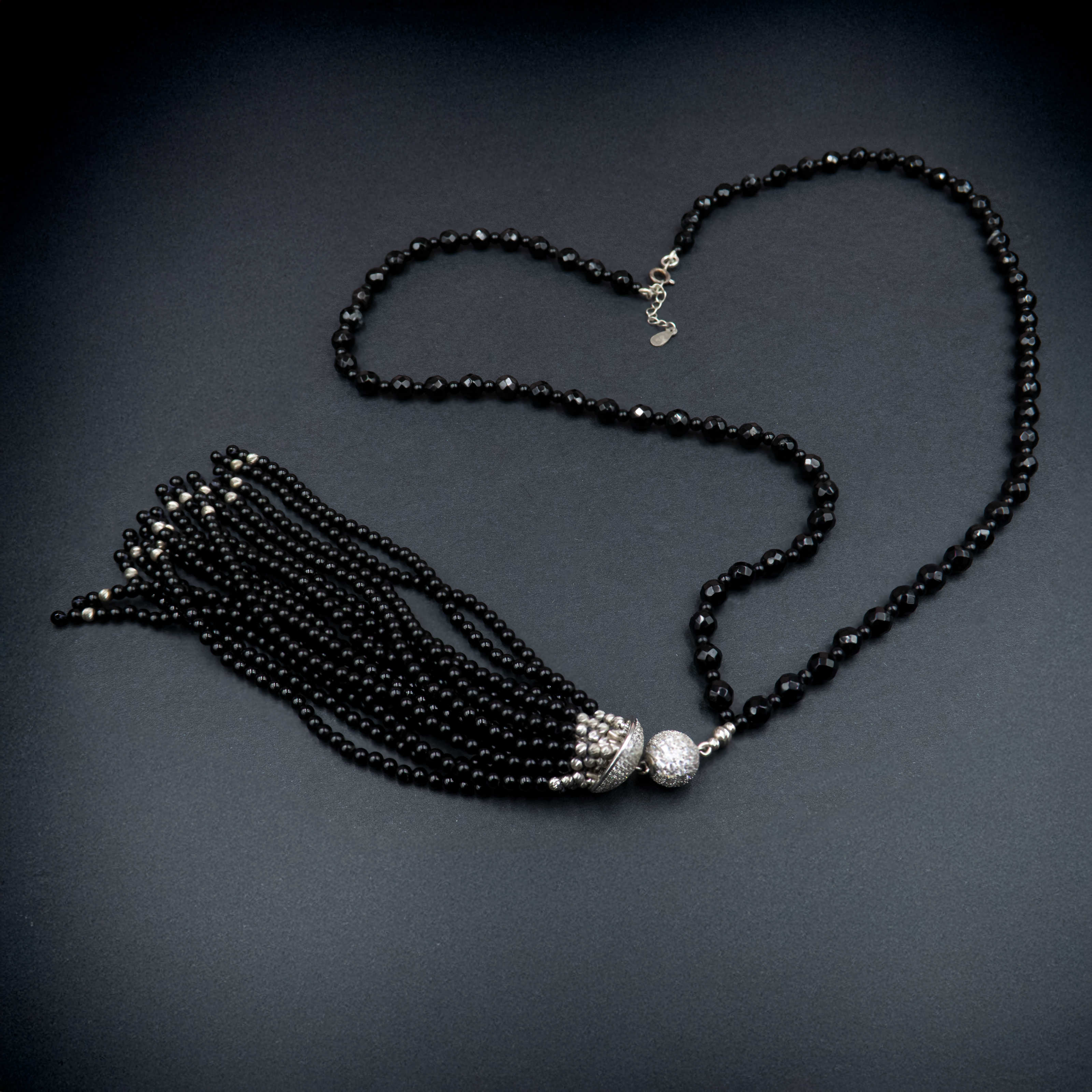 שרשרת סטייטמנט עם אבני אוניקס עמוקות, משולבות בחרוזים קטנים וגדיל דרמטי – תכשיט עם נוכחות אלגנטית ותחושת עוצמה. האבנים השחורות יוצרות מראה עמוק ומתוחכם, בעוד שהגדיל מעניק דינמיקה קלאסית עם טוויסט מודרני. הענק משתלב באופן מושלם עם לבוש ערב או מראה קז'ואל מהודר, ומשדר איזון בין יוקרה שקטה ותחכום עיצובי. כל אבן אוניקס נבחרת בקפידה, מה שמבטיח תכשיט איכותי, מדויק ובעל אמירה עיצובית חזקה. מתאים לנשים שאוהבות לבלוט בעדינות – תכשיט שהוא גם תוספת, וגם מרכז ההופעה.