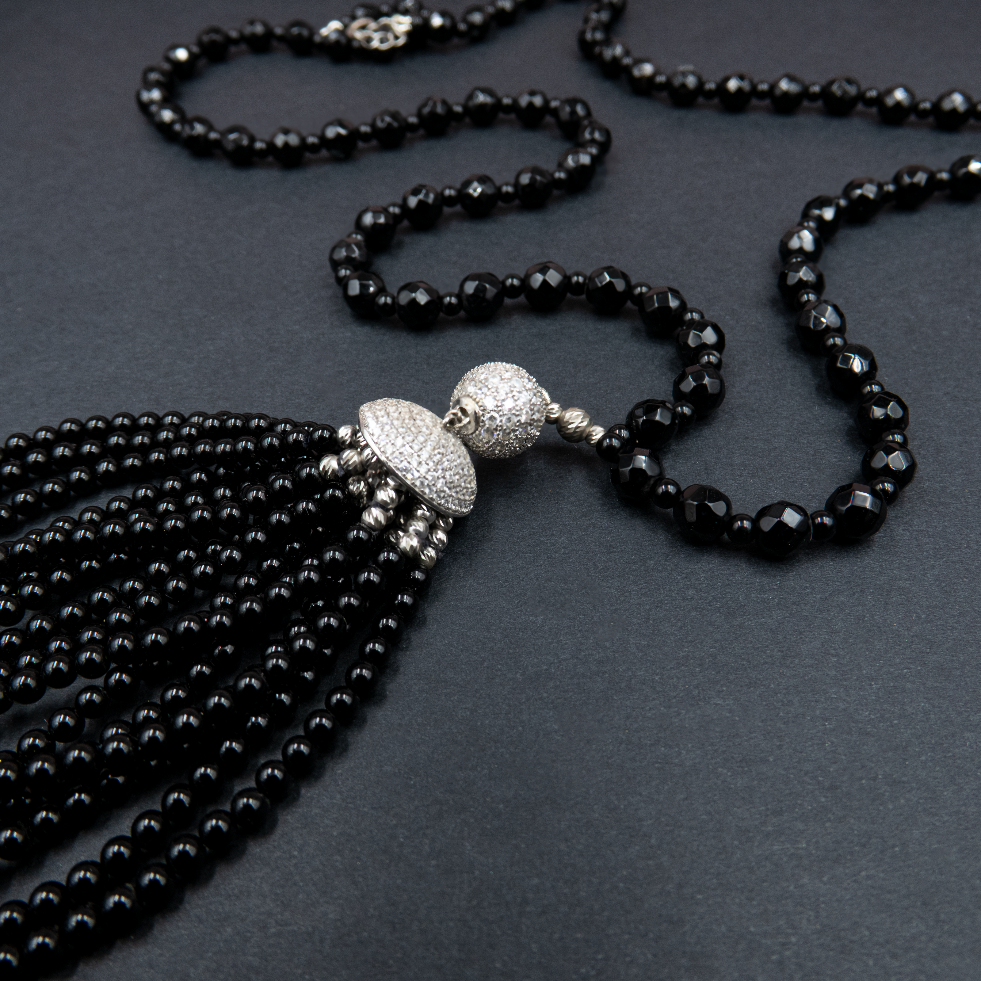 שרשרת סטייטמנט עם אבני אוניקס עמוקות, משולבות בחרוזים קטנים וגדיל דרמטי – תכשיט עם נוכחות אלגנטית ותחושת עוצמה. האבנים השחורות יוצרות מראה עמוק ומתוחכם, בעוד שהגדיל מעניק תחושת תנועה ועניין ויזואלי. הענק משתלב באופן מושלם עם לבוש ערב או מראה קז'ואל מהודר, ומשדר מראה מחוספס־אלגנטי מלא כריזמה. כל אבן אוניקס נבחרת בקפידה, מה שמבטיח תכשיט איכותי, מדויק ובעל אמירה עיצובית חזקה. מתאים לנשים שאוהבות לבלוט בעדינות – תכשיט שהוא גם תוספת, וגם מרכז ההופעה.