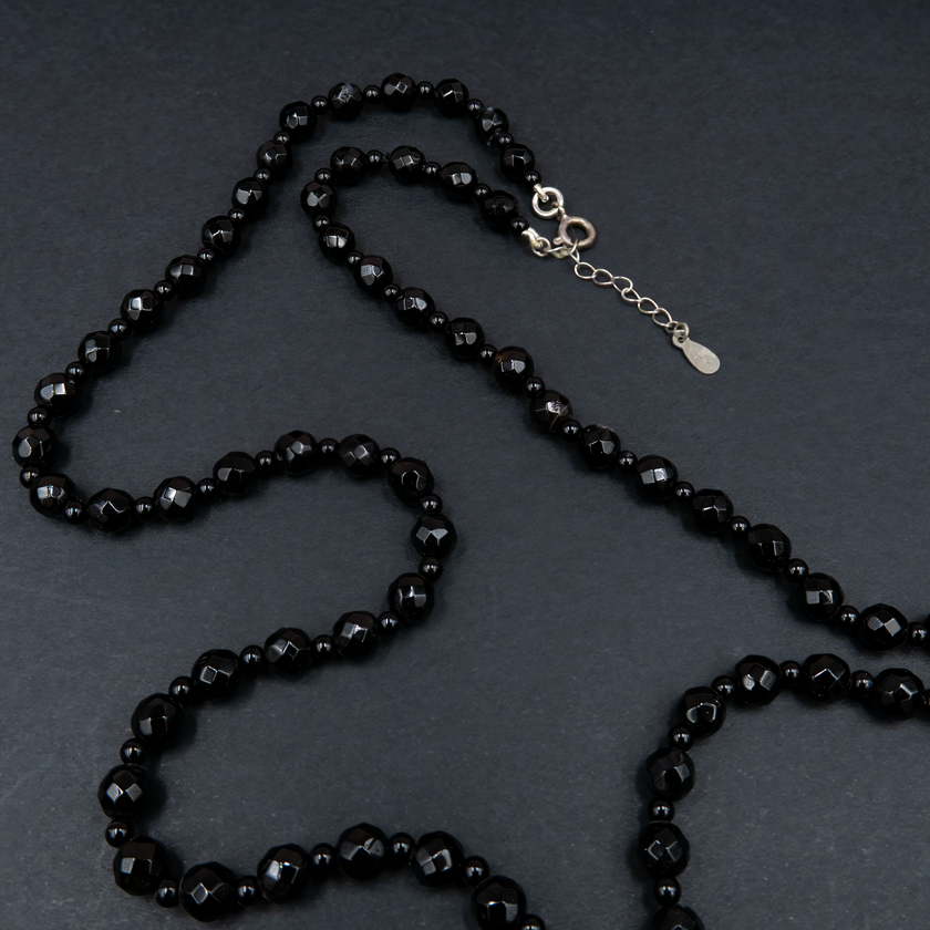 תכשיט דרמטי בגוונים שחורים עם נגיעות זוהר, משולבות בחרוזים קטנים וגדיל דרמטי – תכשיט עם נוכחות אלגנטית ותחושת עוצמה. האבנים השחורות יוצרות מראה עמוק ומתוחכם, בעוד שהגדיל מעניק זרימה רכה ונוכחות עוצמתית. הענק משתלב באופן מושלם עם לבוש ערב או מראה קז'ואל מהודר, ומשדר איזון בין יוקרה שקטה ותחכום עיצובי. כל אבן אוניקס נבחרת בקפידה, מה שמבטיח תכשיט איכותי, מדויק ובעל אמירה עיצובית חזקה. מתאים לנשים שאוהבות לבלוט בעדינות – תכשיט שהוא גם תוספת, וגם מרכז ההופעה.