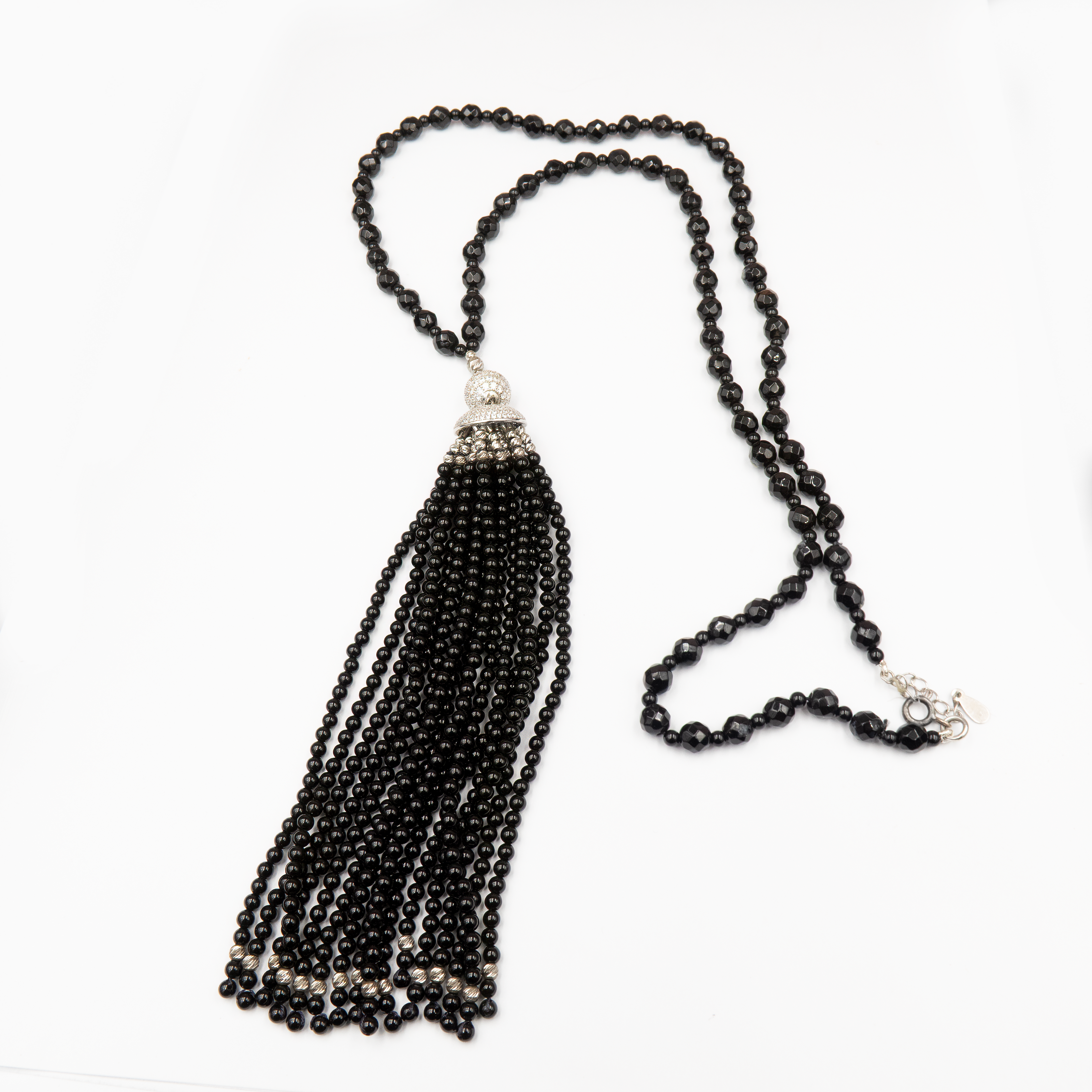 ענק אלגנטי מאבני אוניקס כהות ובוהקות, משולבות בחרוזים קטנים וגדיל דרמטי – תכשיט עם נוכחות אלגנטית ותחושת עוצמה. האבנים השחורות יוצרות מראה עמוק ומתוחכם, בעוד שהגדיל מעניק תחושת תנועה ועניין ויזואלי. הענק משתלב באופן מושלם עם לבוש ערב או מראה קז'ואל מהודר, ומשדר מראה מחוספס־אלגנטי מלא כריזמה. כל אבן אוניקס נבחרת בקפידה, מה שמבטיח תכשיט איכותי, מדויק ובעל אמירה עיצובית חזקה. מתאים לנשים שאוהבות לבלוט בעדינות – תכשיט שהוא גם תוספת, וגם מרכז ההופעה.