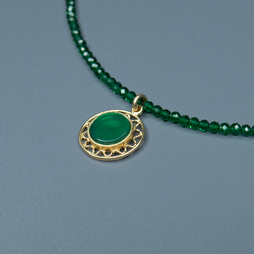 שרשרת שמביאה איתה ניחוח של רוגע וטבע – חרוזים ירוקים קטנים בתנועה קלילה סביב הצוואר, ותליון מוזהב עם אבן ירוקה שמזכירה עלה ירוק אחרי הגשם. תכשיט שמשרה שלווה, עידון וביטחון עצמי שקט. מושלם לנשים שמחפשות יופי פשוט עם עומק.