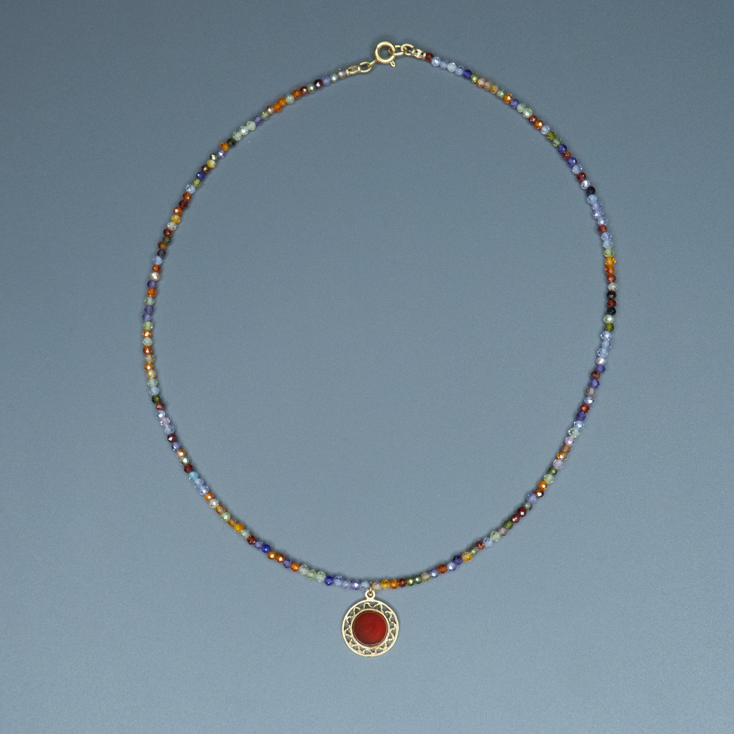 שרשרת אבני חן צבעוניות בגווני קשת עדינים עם תליון קורנליאן עגול במרכז – תכשיט עם קריצה עליזה וטאץ' אישי. החרוזים הקטנים בגווני כחול, כתום, סגול וירוק יוצרים רקע שמאיר את התליון המרכזי, שהוא לב התכשיט. הקורנליאן, אבן הידועה באיכויותיה המחזקות והממריצות, משתלבת כאן בעיצוב שמחבר בין הרמוניה חזותית לאופי אישי. בחירה נהדרת לכל עונה וסגנון לבוש – כזה שמכניס צבע, תחושת חיוניות וחיבור לטבע אל תוך ההופעה שלך.