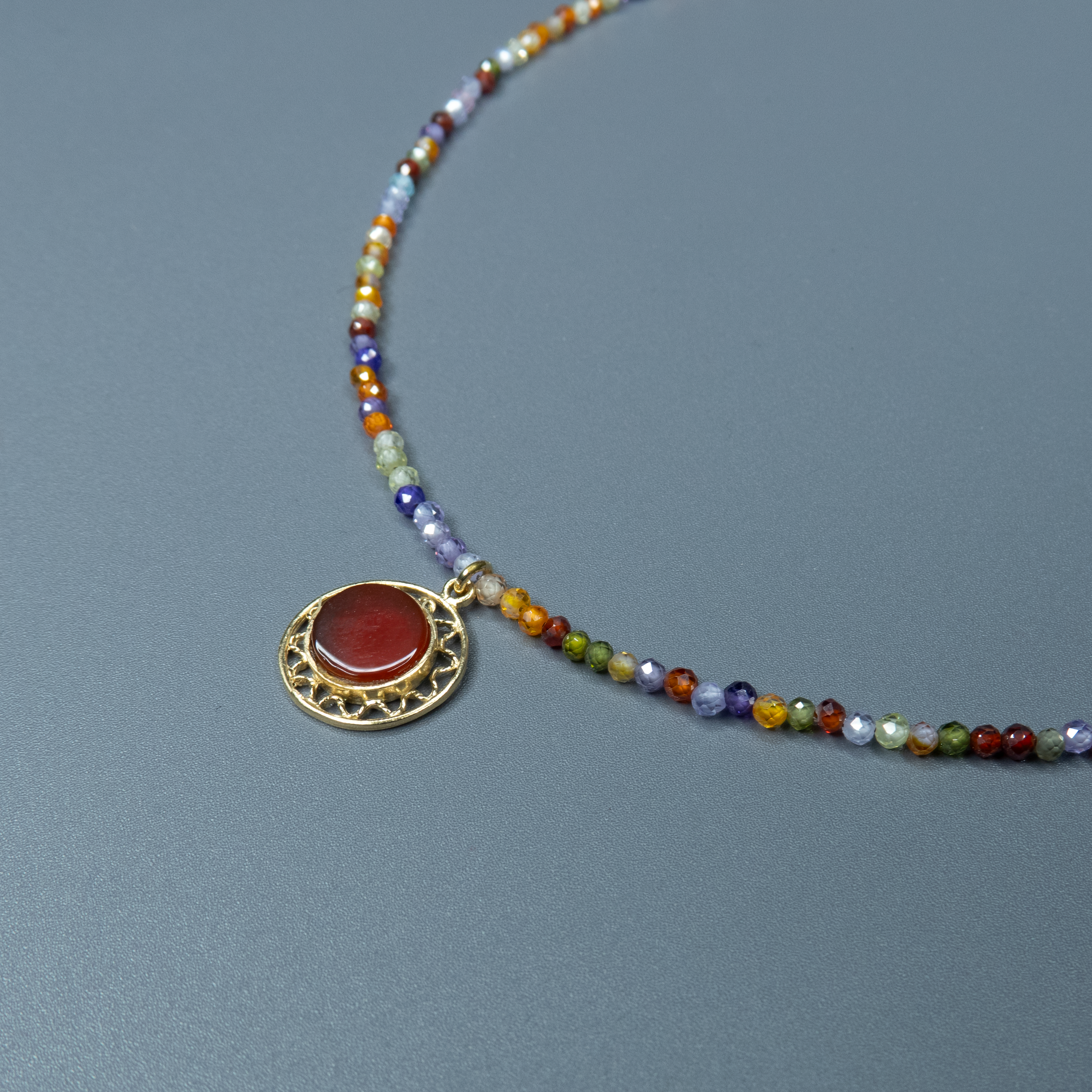 שרשרת אבני חן צבעוניות בגווני קשת עדינים עם תליון קורנליאן עגול במרכז – נגיעה צבעונית עם עוצמה רגשית. החרוזים הקטנים בגווני כחול, כתום, סגול וירוק יוצרים הרכב צבעים שמדגיש את הקורנליאן, שהוא לב התכשיט. הקורנליאן, אבן הידועה באיכויותיה המחזקות והממריצות, משתלבת כאן בעיצוב שמחבר בין הרמוניה חזותית לאופי אישי. תוספת רעננה שתתאים גם לשגרה וגם לחג – כזה שמכניס צבע, תחושת חיוניות וחיבור לטבע אל תוך ההופעה שלך.