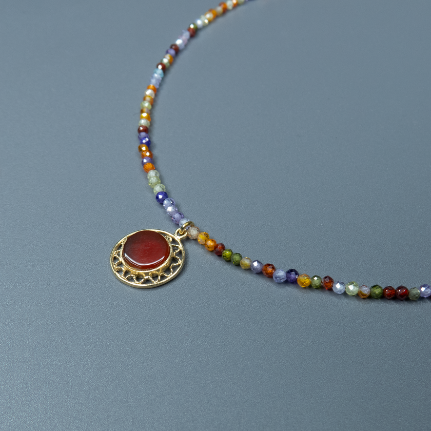 שרשרת אבני חן צבעוניות בגווני קשת עדינים עם תליון קורנליאן עגול במרכז – נגיעה צבעונית עם עוצמה רגשית. החרוזים הקטנים בגווני כחול, כתום, סגול וירוק יוצרים הרכב צבעים שמדגיש את הקורנליאן, שהוא לב התכשיט. הקורנליאן, אבן הידועה באיכויותיה המחזקות והממריצות, משתלבת כאן בעיצוב שמחבר בין הרמוניה חזותית לאופי אישי. תוספת רעננה שתתאים גם לשגרה וגם לחג – כזה שמכניס צבע, תחושת חיוניות וחיבור לטבע אל תוך ההופעה שלך.