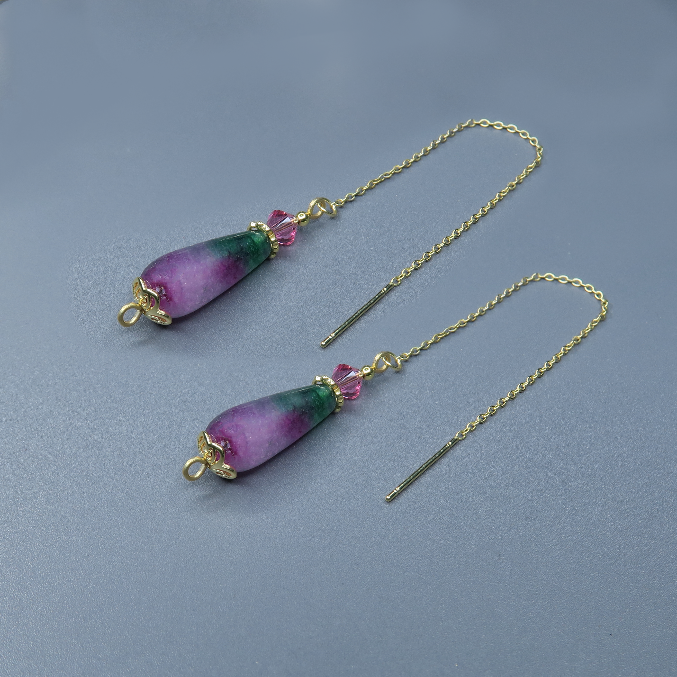 עגילי שרשרת עם אגת צבעונית בגוונים משתלבים – סגול, ורוד, ירוק, טורקיז ועוד. העיצוב הדקיק והקליל מאפשר לאבן לבלוט ולהתבטא. כל תנועה חושפת זווית אחרת של צבע, תנועה ואור. מתאים לנשים שמחפשות עגיל מלא חיים, קל ללבישה ומעורר השראה.

