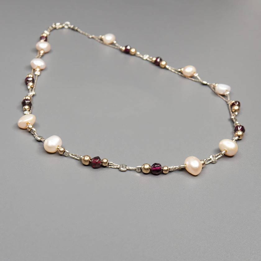 שרשרת כסף בעבודת יד המשלבת פנינים לבנות טבעיות עם גרנטים עמוקים בגוון יין – שילוב ייחודי בין רוך הפנינה לעומק הדרמטי של הגרנט. הפנינים מוסיפות אור ורכות לכל הופעה, בעוד שהגרנטים מביאים עומק, חמימות ונשיות עם נוכחות שקטה ומרגשת. השרשרת עשויה מכסף סטרלינג 925, עם סגירה מעודנת שמשלימה את הקו האלגנטי של התכשיט. תכשיט שמתאים לאירועים מיוחדים אך גם לבעלות סגנון אישי שמבקשות לשלב מראה על־זמני עם קריצה עדכנית.