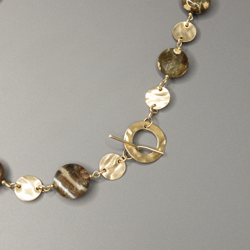 שרשרת אבן פיקאסו בעיבוד ייחודי בעבודת יד, עם גולדפילד עדין ונצחי ונגיעות של עיצוב בוהו־שיק טבעי. האבנים בגווני טבע חמים, יוצרות מראה הרמוני, עשיר ומעורר סקרנות – כל אבן נראית כמו ציור מינרלי ייחודי. השרשרת משלבת בין צבעים חמים, מרקמים חיים וזוהר עדין של זהב, ומעניקה תחושת עומק, קרקע ונשימה איטית. מתאימה לנשים עם סגנון אישי מובהק, שמחפשות תכשיט ייחודי, מעודן אך נוכח, שמשדר אהבה לחומרים אמיתיים. פריט מושלם ליום־יום עם טאץ' אחר, או כתוספת שקטה אך אלגנטית למראה ערב פשוט ונעים.