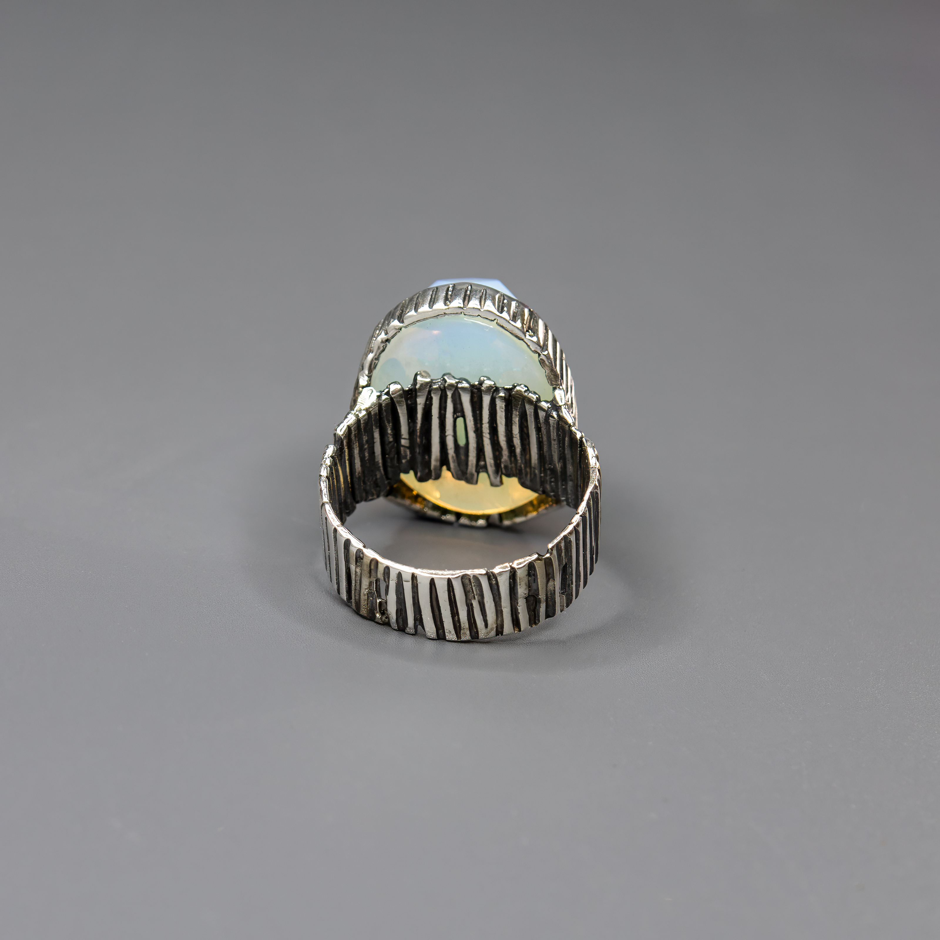 תכשיט כסף בעבודת יד המשולב באבן אופליט לבנה בצורת אובלית, בעלת ערפילי ועדין שמעניק תחושת ניקיון, רוגע והרמוניה. האבן הלבנה מלוטשת למראה חלק ונעים למגע, ומשדרת זוהר שקט המשתנה בהתאם לזווית התאורה – לפעמים נראית כמעט שקופה, לפעמים עם ברק פנינתי עדין. היא מהווה נקודת אור מרכזית בתכשיט, ומתאימה לאוהבי עיצוב אלגנטי, מינימליסטי ובעל השראה שקטה. האבן מסמלת אנרגיה רגועה וטוהר לב – מושלמת כתוספת ייחודית למראה יומיומי בהיר, וגם כתוספת קלאסית למראה חג. מתנה מעולה לאישה שאוהבת תכשיטים שקטים עם משמעות עמוקה וזוהר שקט אמ