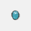An oval silver ring with an ocean-hued opalite