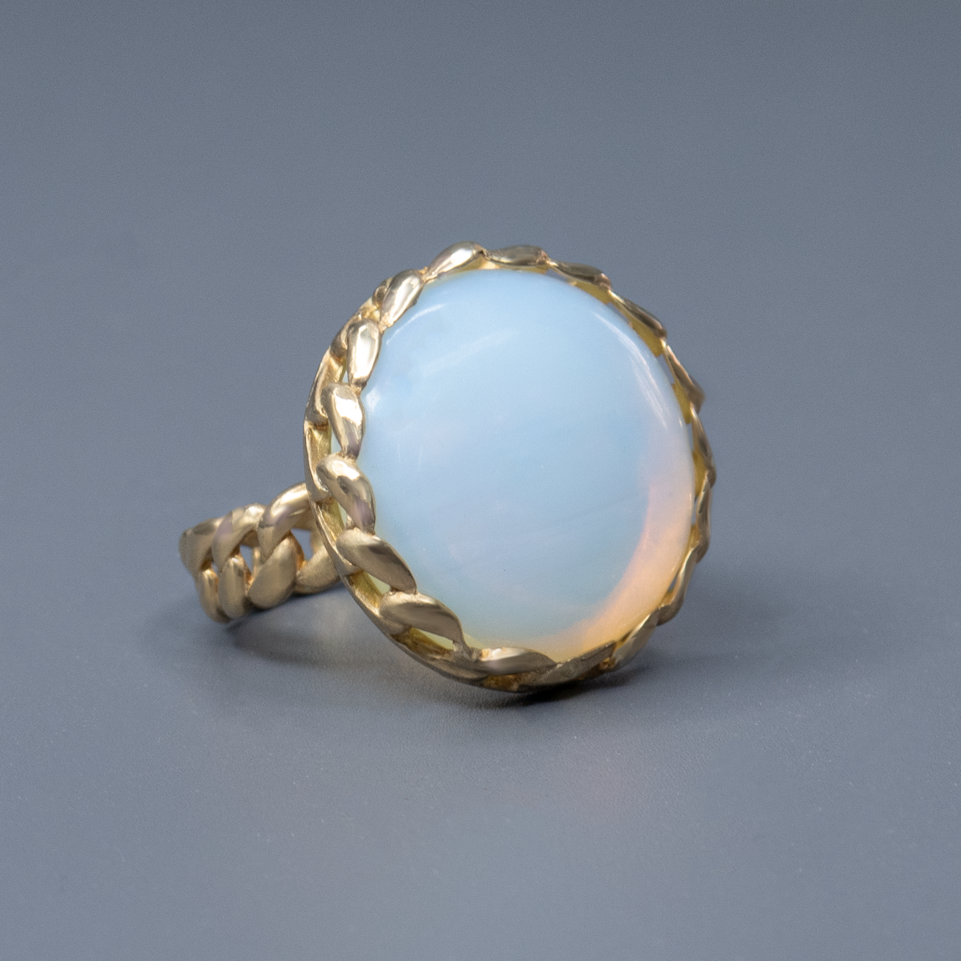 אבן אופליט בגוון מיסטי של מון סטון משובצת בטבעת כסף עדינה אך בולטת. הצבע נע בין כחול מעושן ללבן פנינה, עם אפקט אור פנימי שמזכיר אבן ירח אמיתית. טבעת שמספרת סיפור – על רוך, חלום וקסם של עולמות פנימיים.

