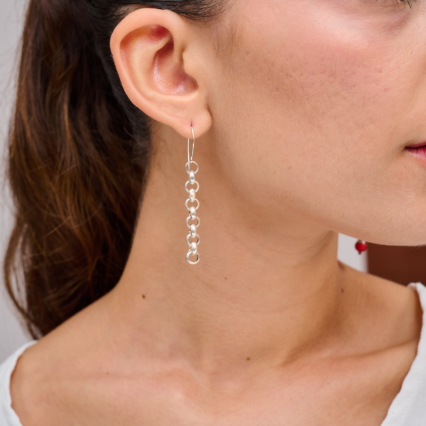 עגילים ארוכים וקלילים בעיצוב מודרני משרשרת כסף דקה ומעוטרת, ללא אבנים. תכשיט ייחודי בעבודת יד שמשדר תחכום וסטייל עכשווי. מתנה מקורית לחברה, אחות או לעצמך – לנשים שמעריכות קווים נקיים, איכות ועבודת יד מוקפדת.


