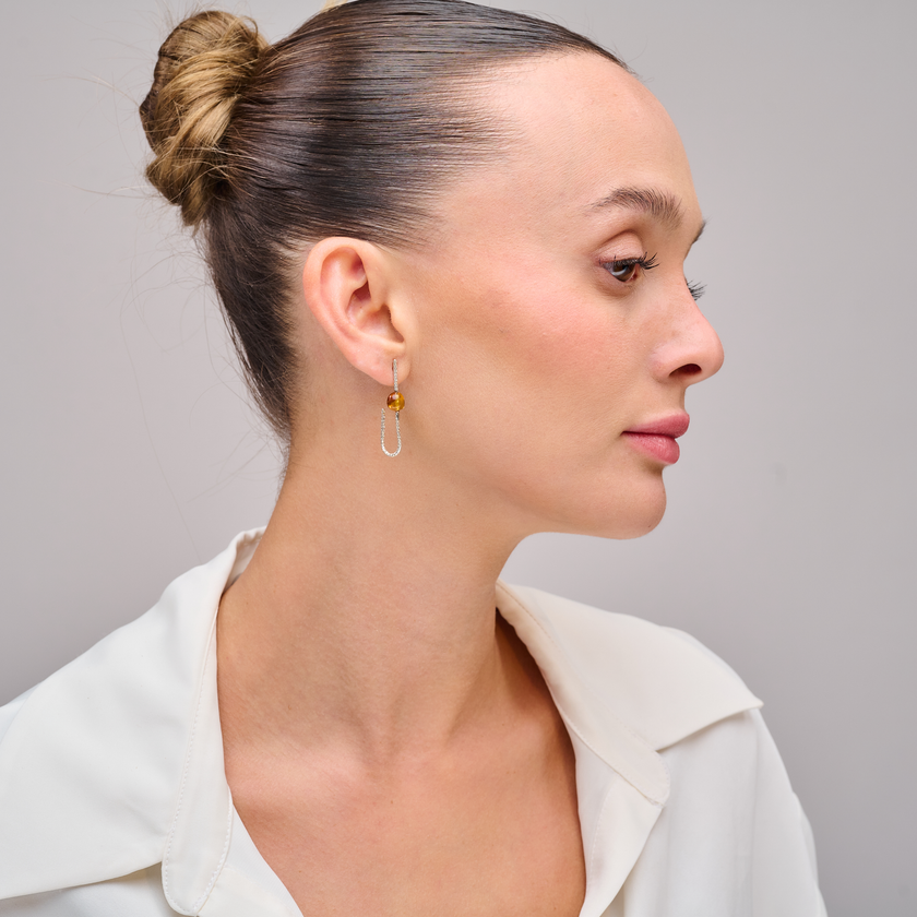 עגילים בעיצוב אלגנטי עם ענבר טבעי בגוון דבש – תכשיט קלאסי בעל ברק פנימי חמים. האבן השקופה מהפנטת ביופייה, ויחד עם המתכת הכסופה נוצרת הרמוניה בין טבע לנשיות מעודנת. מתנה מושלמת לכל גיל, לכל עונה, ולכל מי שמחפשת תכשיט בעבודת יד עם סגנון נצחי.

