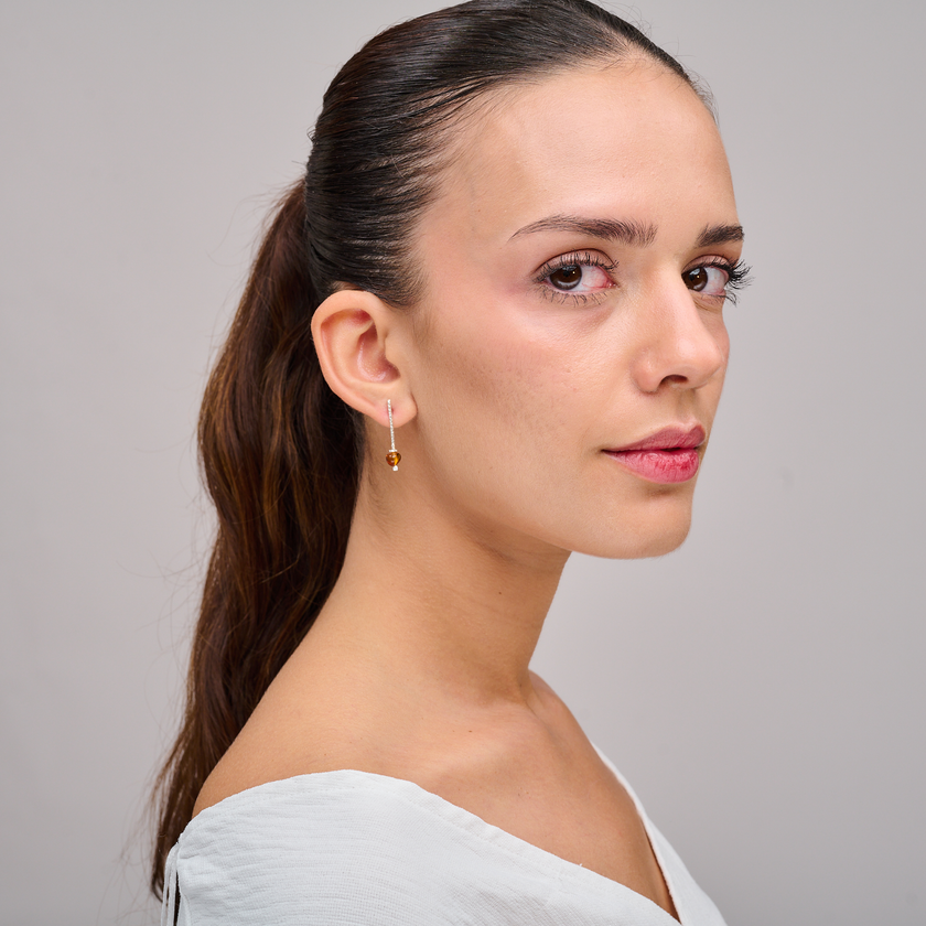 עגילים עדינים אך מלאי אופי מזהב 14 קראט עם ענבר אמיתי – כל אבן נושאת בתוכה קפסולת זמן מהטבע: שקופה, חמה ומלאת חיים. גוני הדבש-זהוב של האבן יוצרים ניגוד מרהיב עם ברק הזהב, והעיצוב שומר על פשטות שמבליטה את הטבעיות של החומר.
הענבר נושא אנרגיה עתיקה של הגנה, שמחה ובריאות, ומומלץ מזה דורות לאנשים שמחפשים איזון רגשי ותחושת ביטחון. תכשיט שנותן תחושה אישית, אינטימית וחיה – כאילו כל עגיל לוחש סיפור של אור.