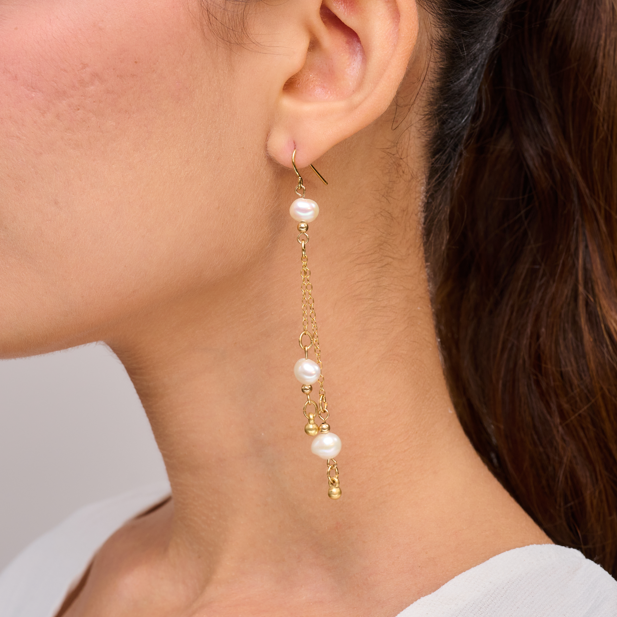 עגיל אלגנטי וארוך במיוחד עם שלוש פנינים לבנות הקשורות לשרשרת זהובה דקיקה. העיצוב המשולש נותן תחושת גובה ותנועה, מתאים במיוחד למראה ערב, כלה או הופעה חגיגית. הפנינים מוסיפות זוהר טבעי ונגיעת רכות לתכשיט מודרני ומרשים. מתאים לנשים עם טעם קלאסי ונשי.

