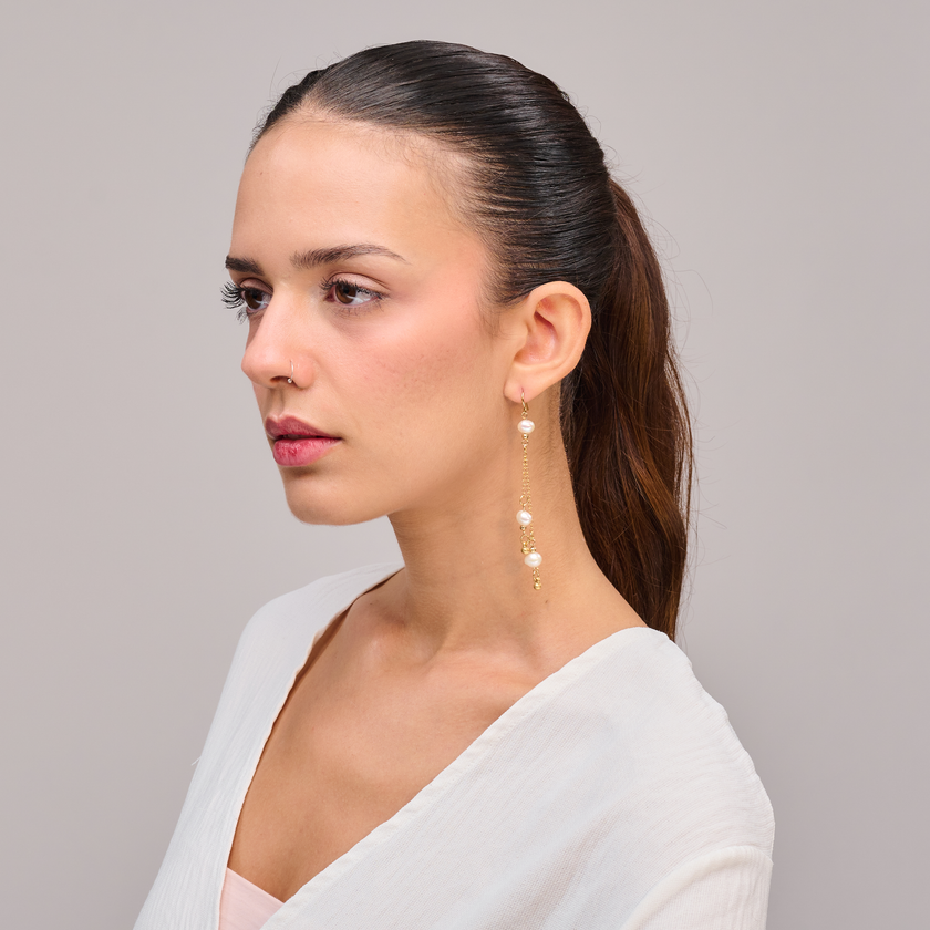 עגיל תלוי באורך מלא עם שלוש פנינים טבעיות קטנות וחרוזים מוזהבים בולטים, המשתלשלים משרשראות זהב דקיקות. שילוב עדין ומרשים בין אלגנטיות רכה לנוכחות נוצצת. מתאים לכלה, לחתונה, לאירוע חשוב או להשלמת מראה ערב עם טאץ' נשי ונצחי. עיצוב בעבודת יד עם תשומת לב לפרטים הקטנים.

