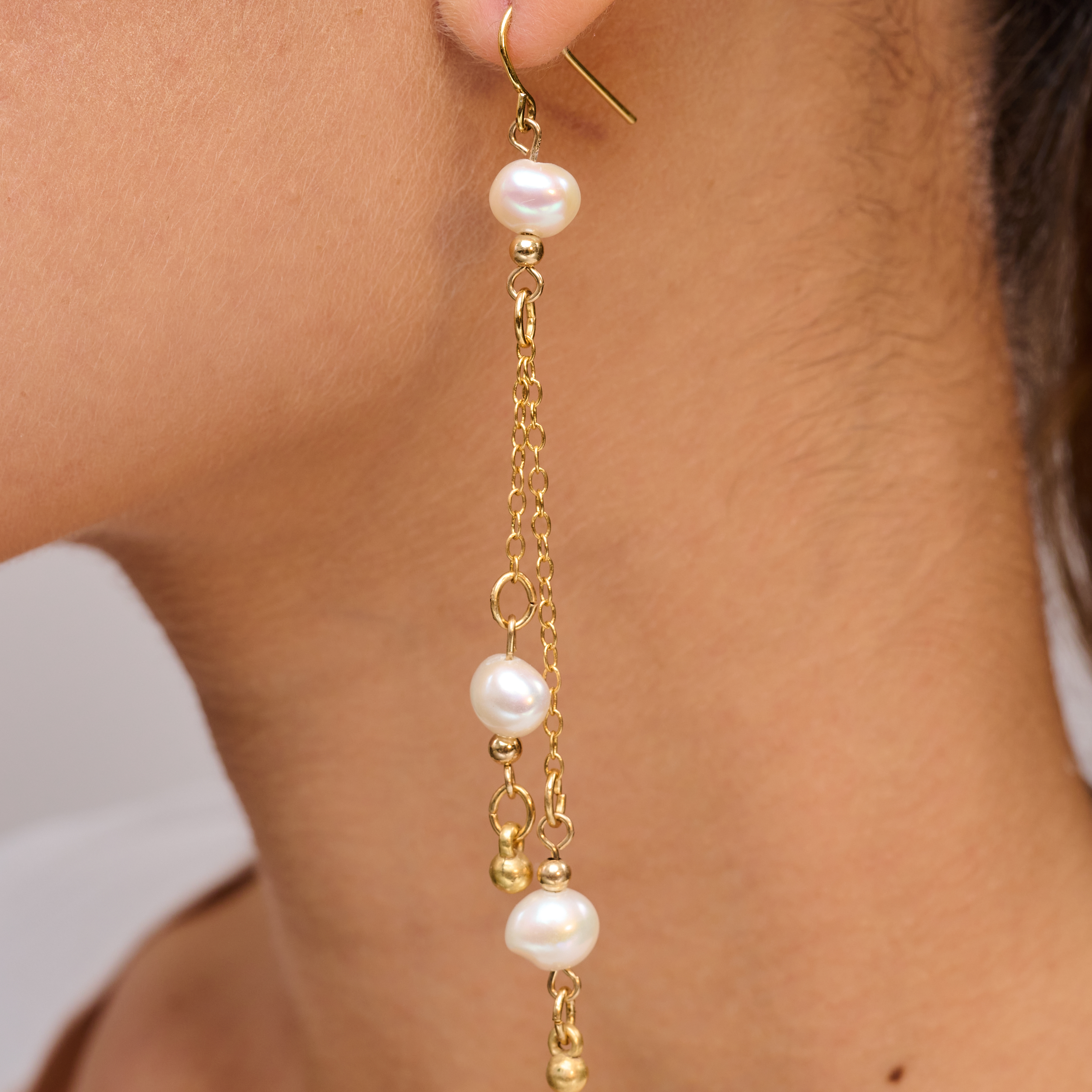 עגיל ארוך ואלגנטי בעיצוב עדין ומוזהב, משולב בשלוש פנינים לבנות טבעיות וחרוזים קטנים בגוון זהב. השרשראות הזהובות משתלשלות ברכות ומוסיפות תחושת תנועה ונוכחות מחמיאה. הפנינים מעניקות לעגיל מראה קלאסי עם טוויסט מודרני. תכשיט מושלם לערב, חתונה או כל אירוע חגיגי. מתאים לנשים שאוהבות סטייל נשי, רך ומתוחכם.

