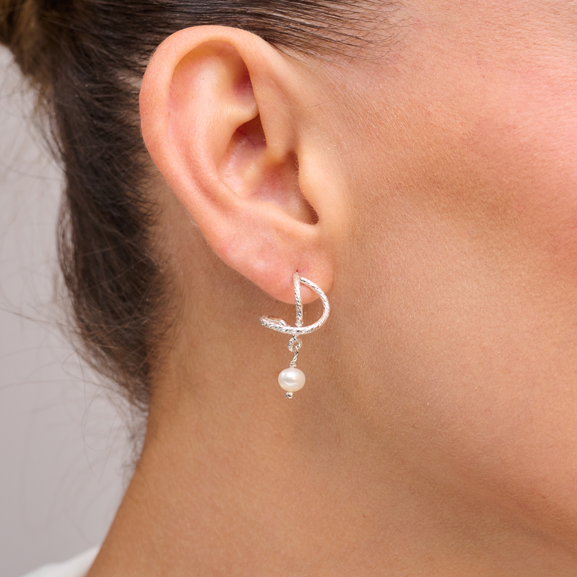 עגילי כסף בעיצוב קלאסי עם פנינה לבנה – תכשיט שמבטא אלגנטיות על-זמנית ונשיות מעודנת. הפנינה הלבנה מביאה עמה תחושת טוהר ואור רך, המשתלבת בהרמוניה עם גימור הכסף הנקי. עגילים קלים ונוחים, מושלמים ללבישה ממושכת – מהעבודה ועד אירוע ערב. מתנה אידיאלית לכלות, לאירועים חגיגיים או לנשים שמעדיפות תכשיטים עדינים עם נוכחות אמיתית.

